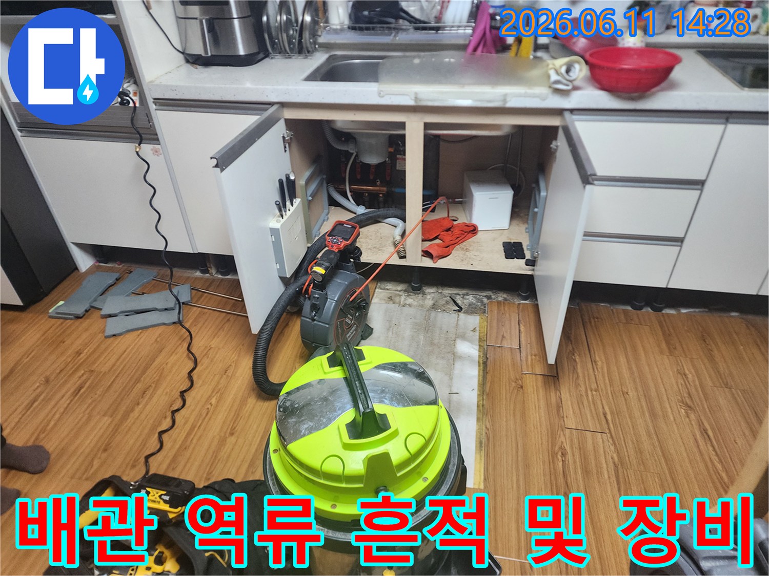 싱크대 하부 배수관 주변의 역류 흔적과 작업용 석션기