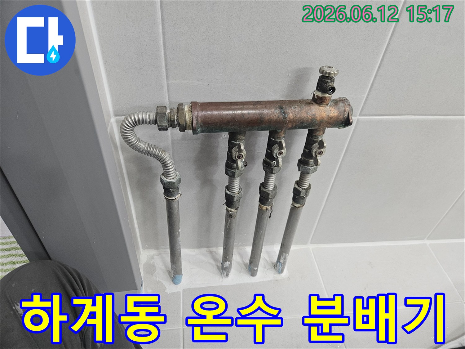 하계동 아파트의 온수 배관 분배기에서 누수 징후가 포착되어-전문가가 노후된 배관과 밸브 상태를 꼼꼼히 확인하고 있습니다