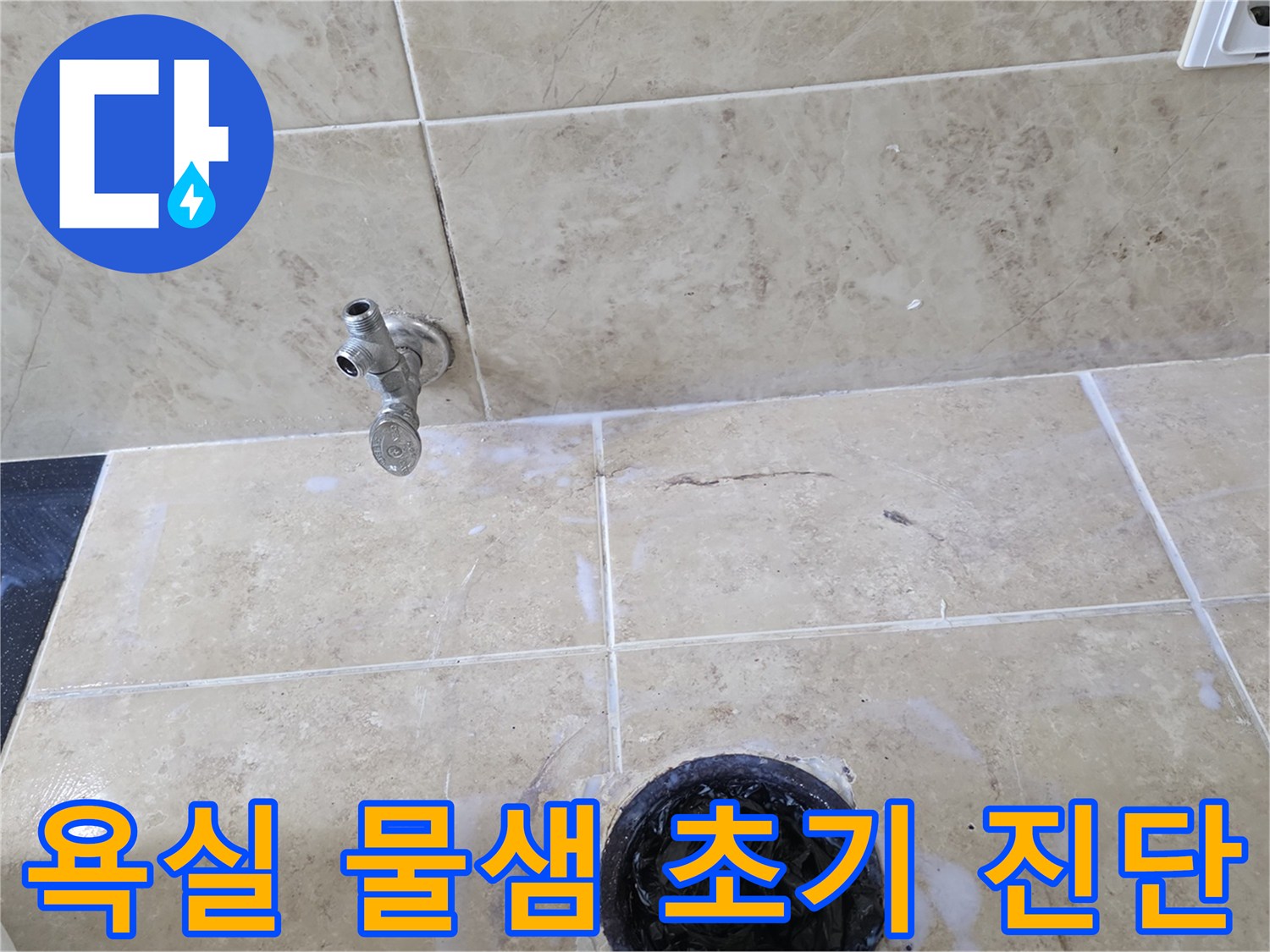 욕실 바닥의 수도꼭지와 배수구 주변에 나타난-하얀 물때 자국과 타일 균열을 보여주는 현장 사진입니다