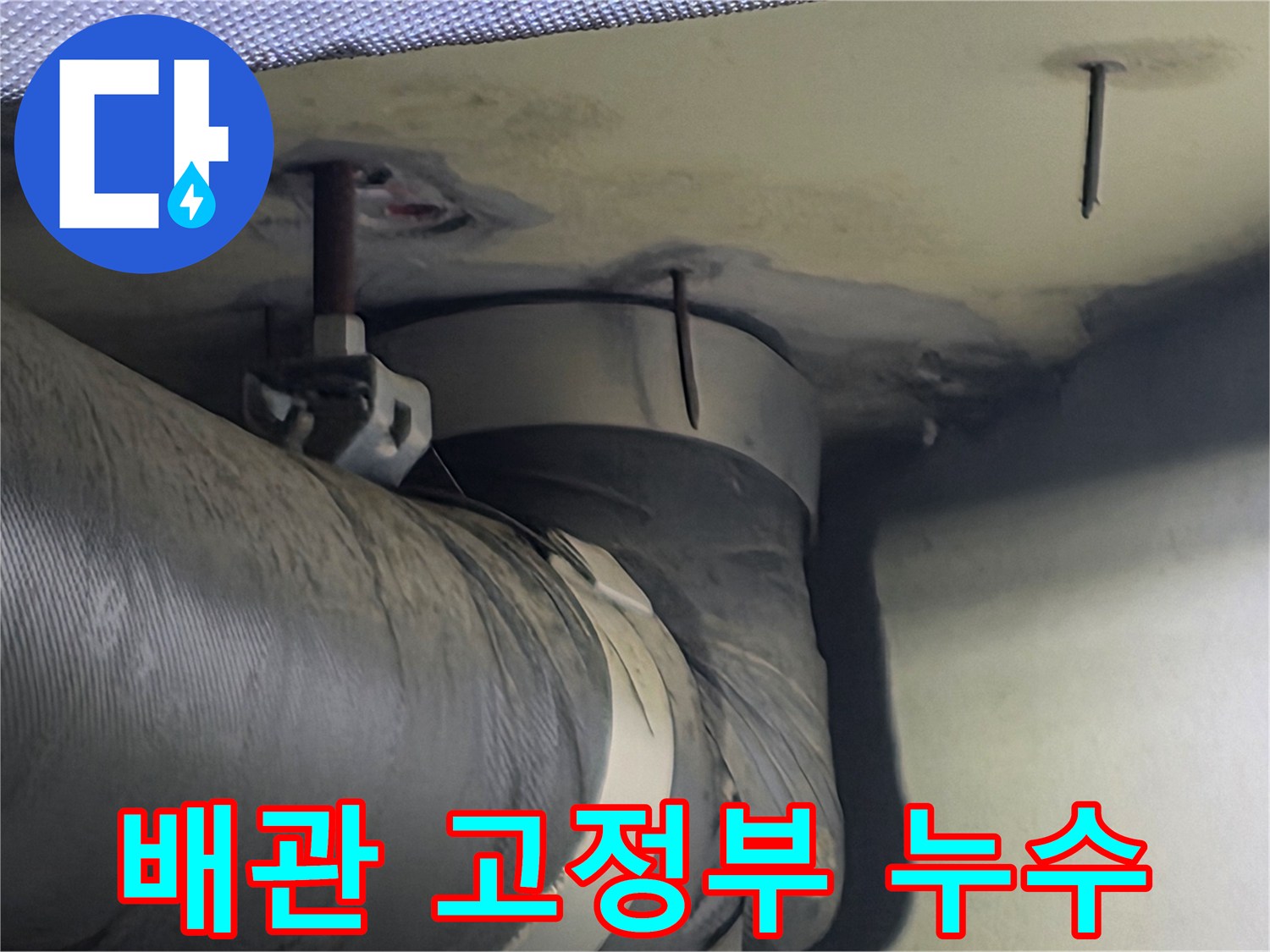 천장 배관 고정부 주변에 나타난 습기와 누수 흔적-이는 배관 연결부의 문제일 수 있습니다
