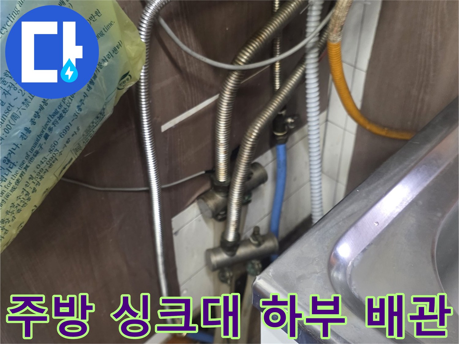 싱크대-하부장-아래에-얽혀있는-금속-자바라-배관과-수도-연결부-상태