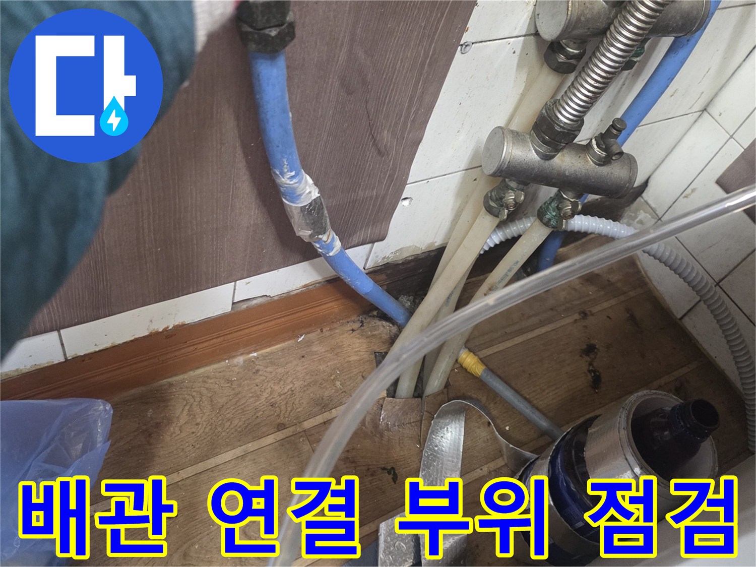 하부장 내부의 복잡한 수도 배관과 밸브 연결 상태입니다