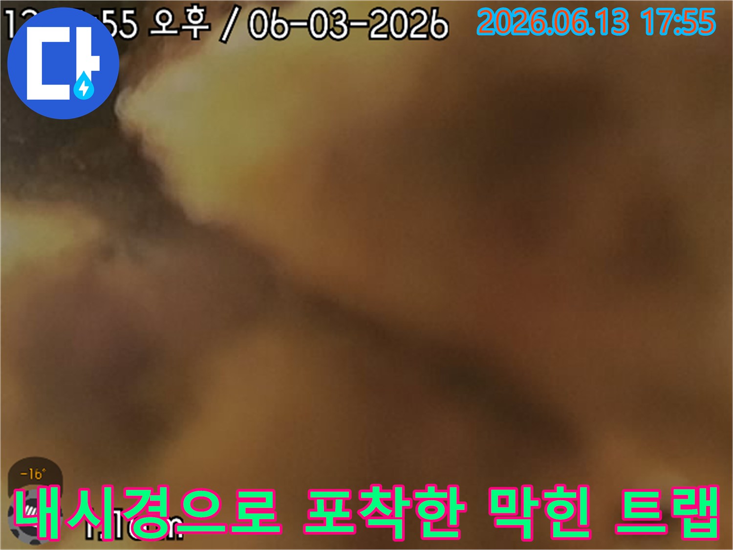 오물과 슬러지가 엉겨 붙은 배관 내부를 내시경으로 촬영한 사진입니다.
