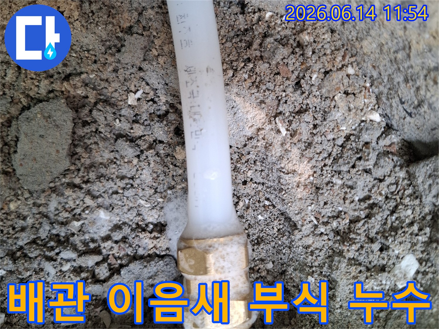 땅속에-묻힌-배관의-금속-연결부에서-부식으로-인한-누수가-발생하여-주변-흙이-젖어있는-모습을-보여주는-사진
