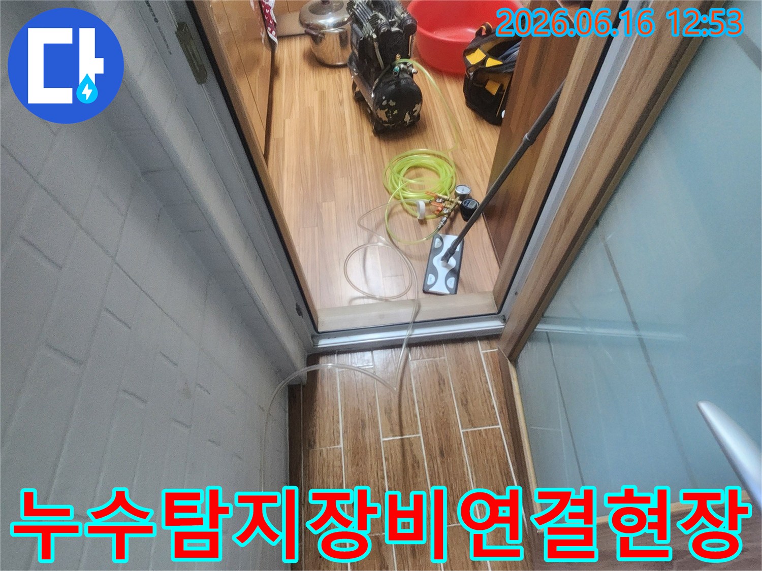 누수 엔지니어가 아파트 내부에서 누수-탐지 장비를 연결하며 작업 준비를 하고 있습니다.