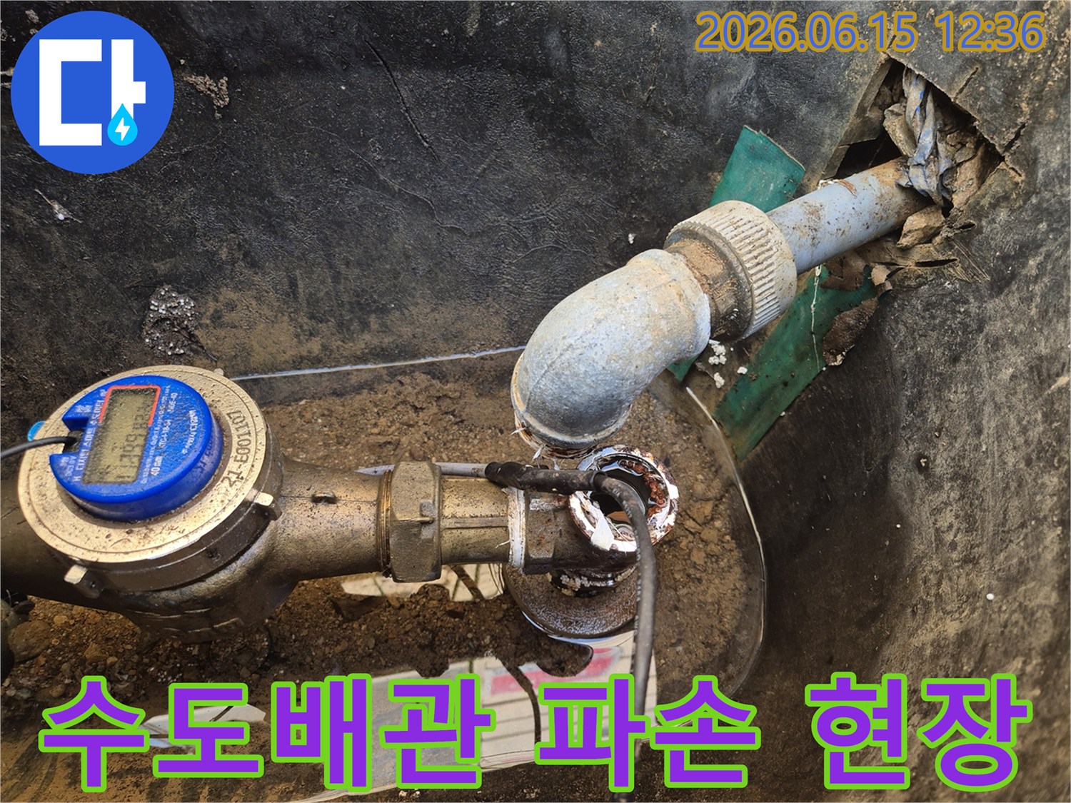 이 이미지는-수도배관 연결부의-심각한-파손과-부식으로-인한-누수 현장을-보여줍니다-물이-주변에-고여있는-모습입니다