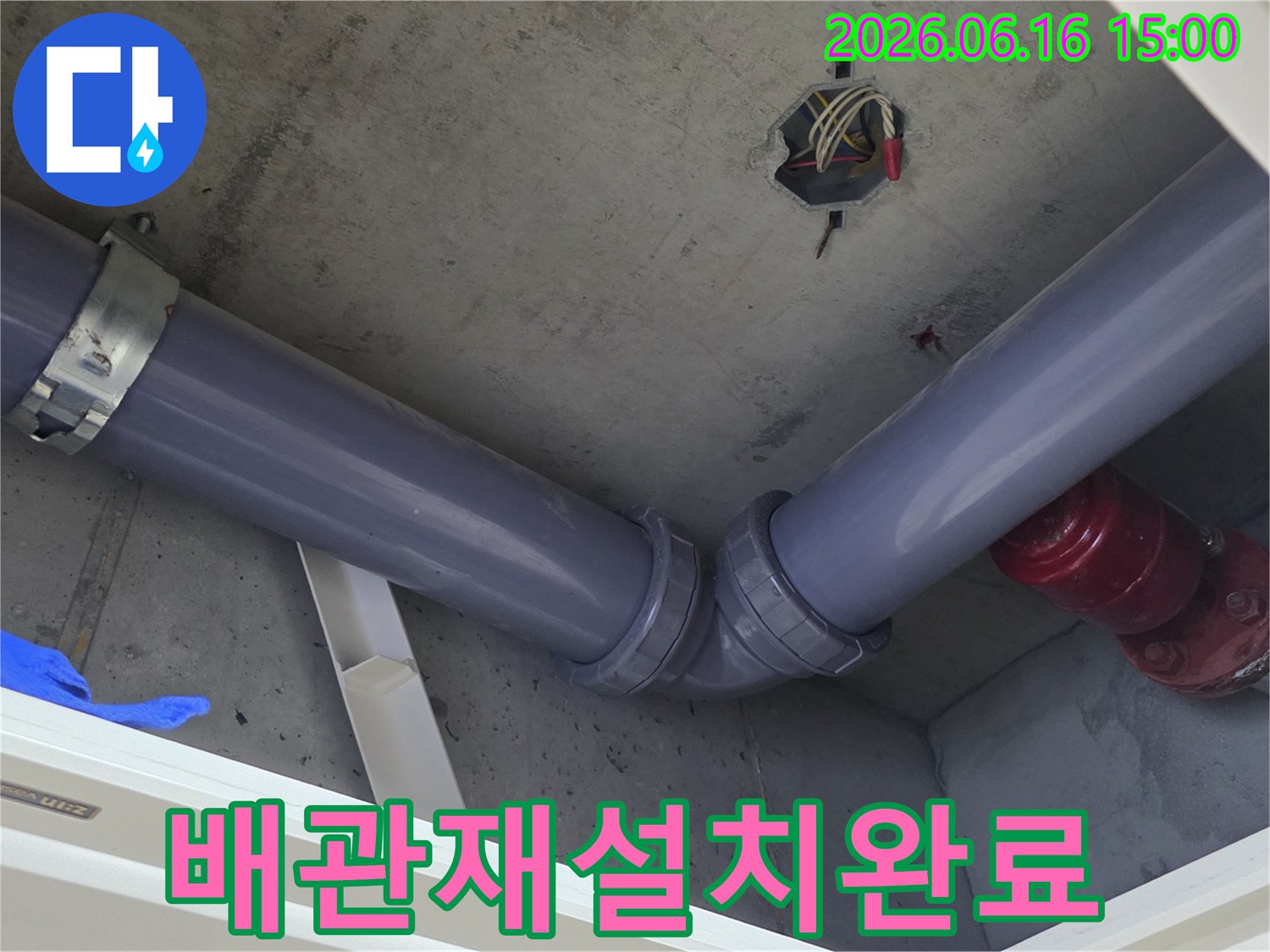 콘크리트-천장 아래-새롭게-설치된-회색 배관이-견고하게-연결되어-있는-배관 재설치-현장
