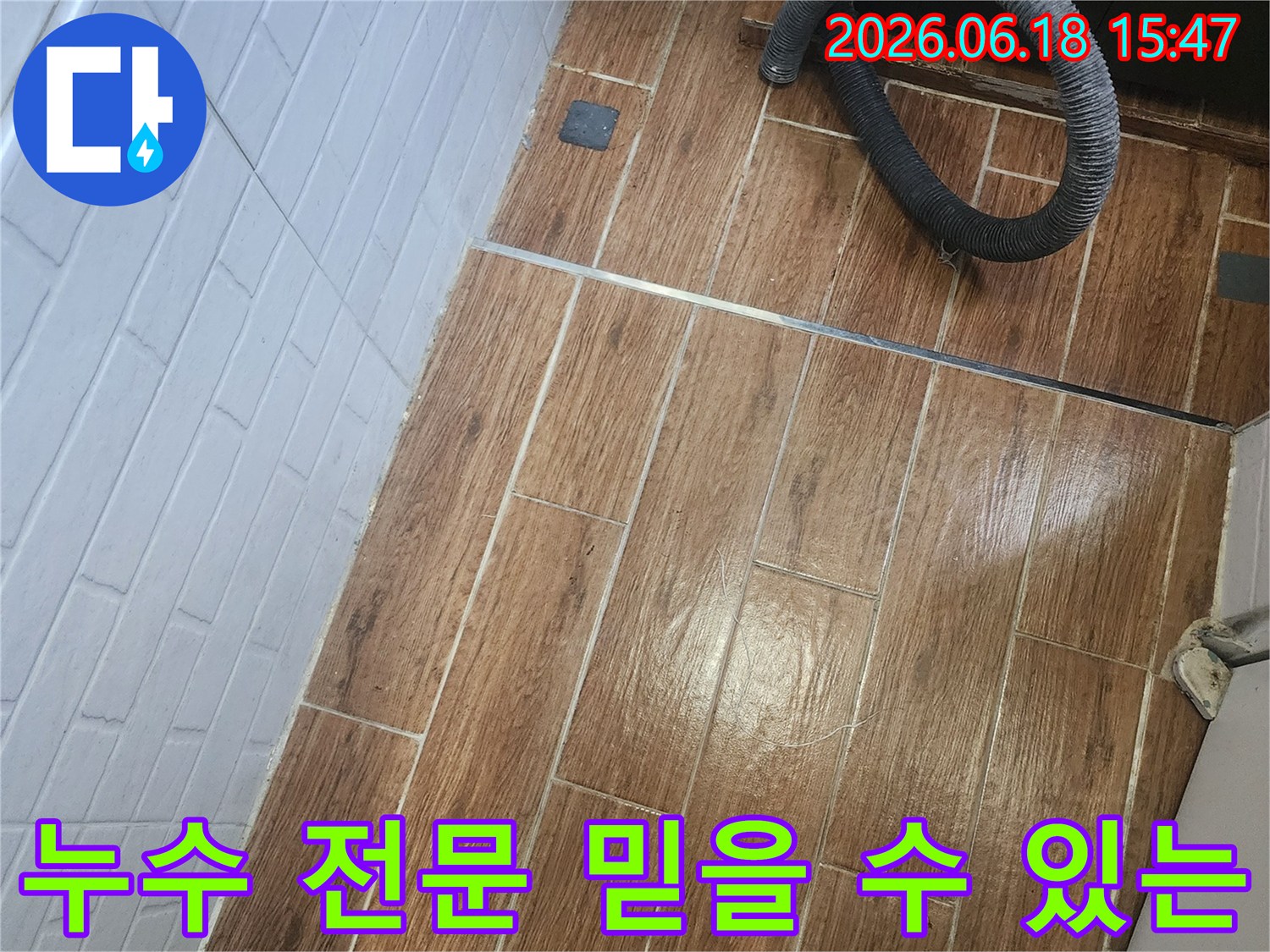 염창동 아파트에서 믿을 수 있는 누수 전문 서비스를 위해 탐지 작업이 진행 중인 현장입니다-바닥 타일 위에 검은색 호스가 놓여 있습니다.