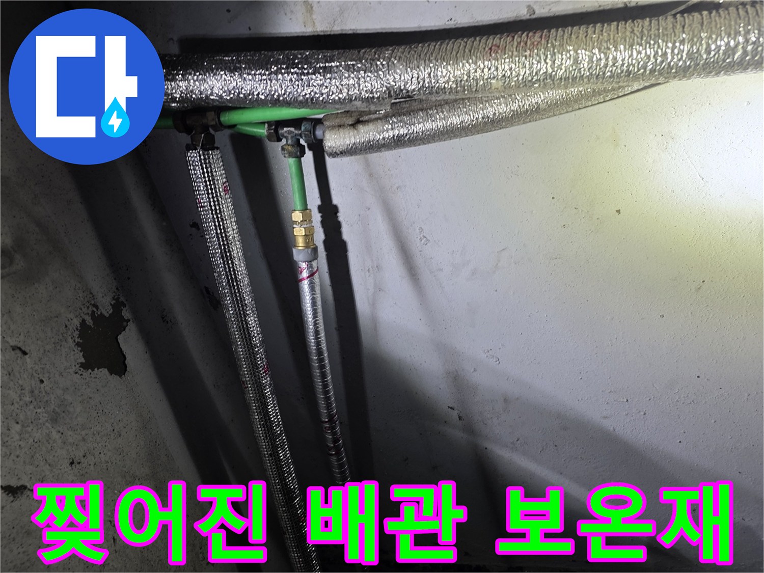 벽면 배관의 보온재가 찢어져 내부 연결 부위가 노출된 모습
