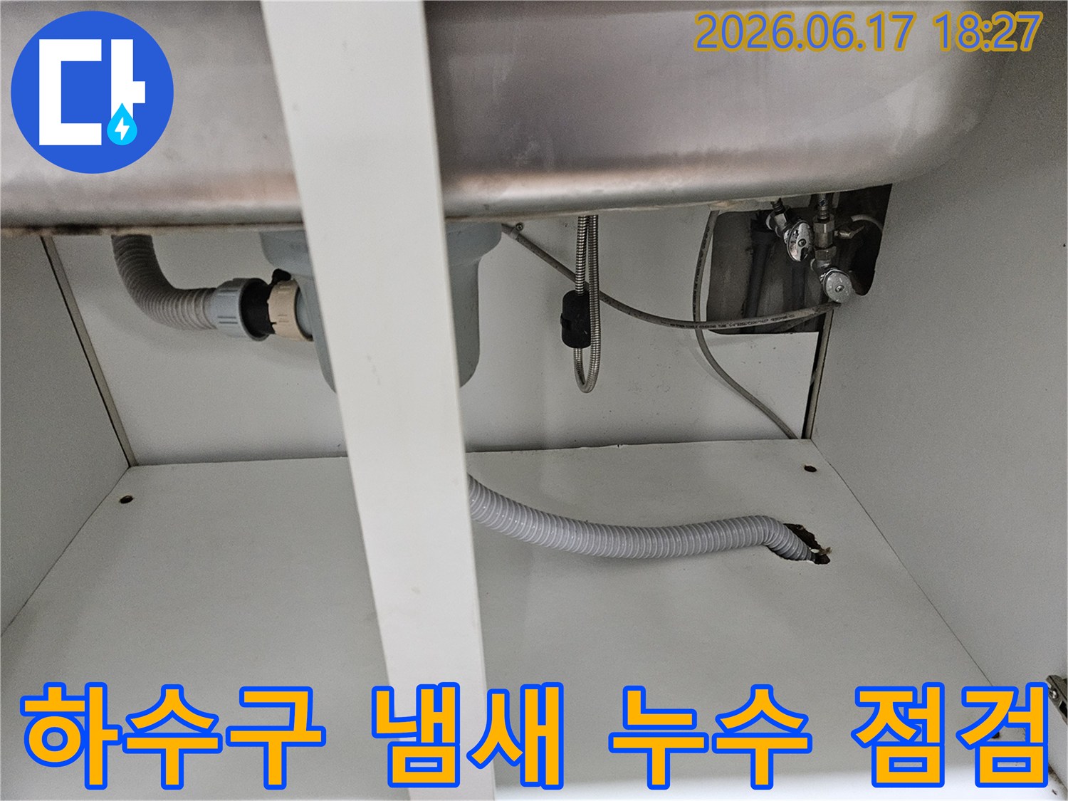 싱크대 하부 배관에서 발생하는 하수구 냄새와-누수 문제를 동시에 점검하는 현장 사진입니다