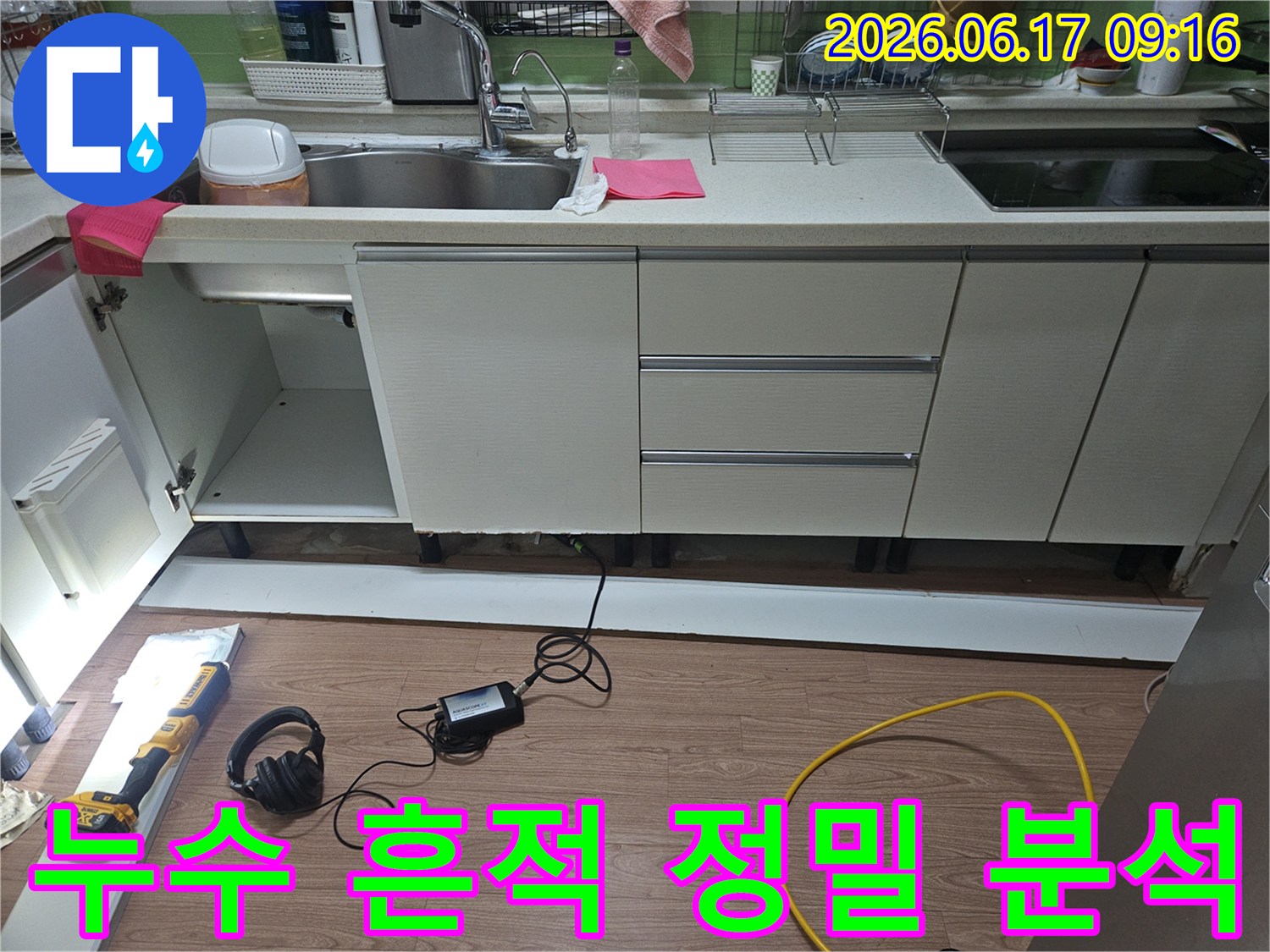 싱크대 하부장에 물기가 있는 현상에서-누수 원인을 분석하기 위해-전문 장비를 사용하여-하부 공간을 정밀하게 검사하는 모습