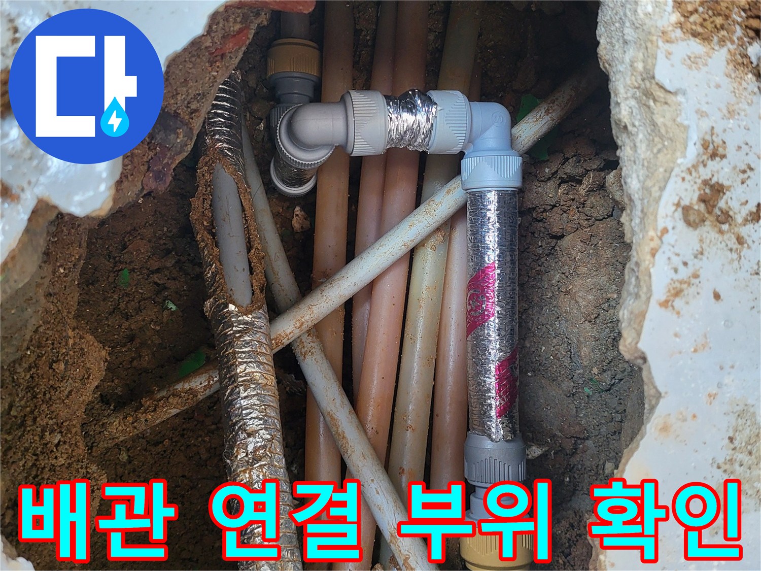 지면 아래 드러난 여러 갈래의 수도 배관과 보온재 작업