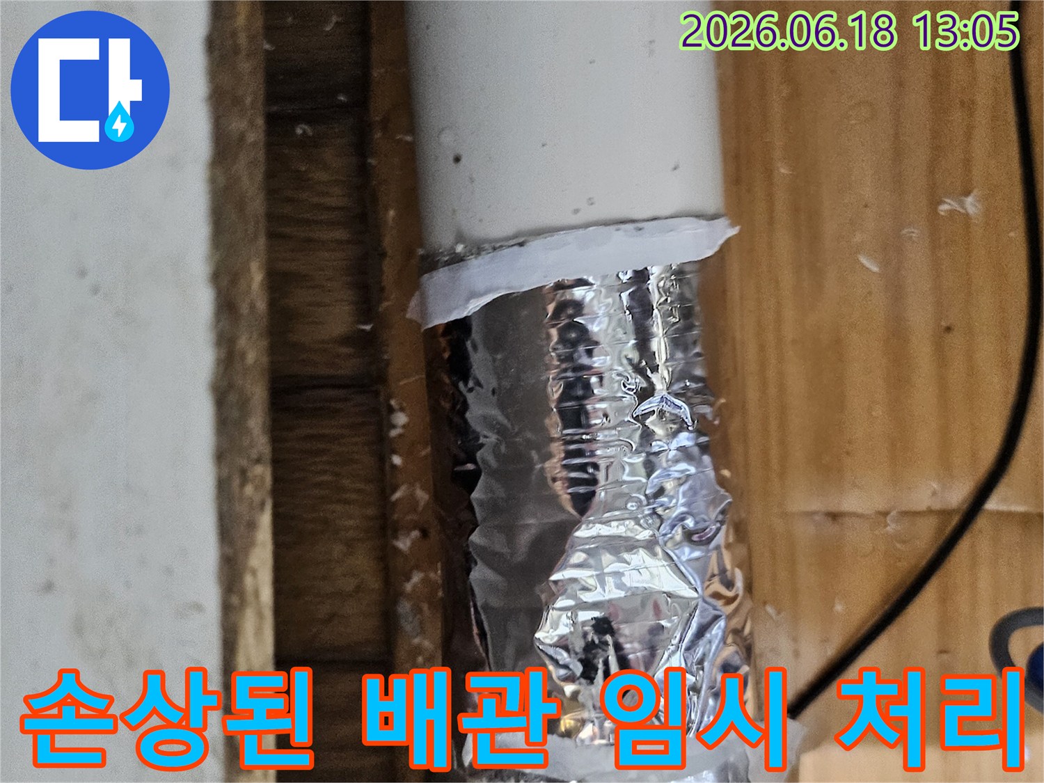 손상된 배관 부위를 알루미늄 호일과 테이프로 임시 보수한 모습-누수 공사 전 단계