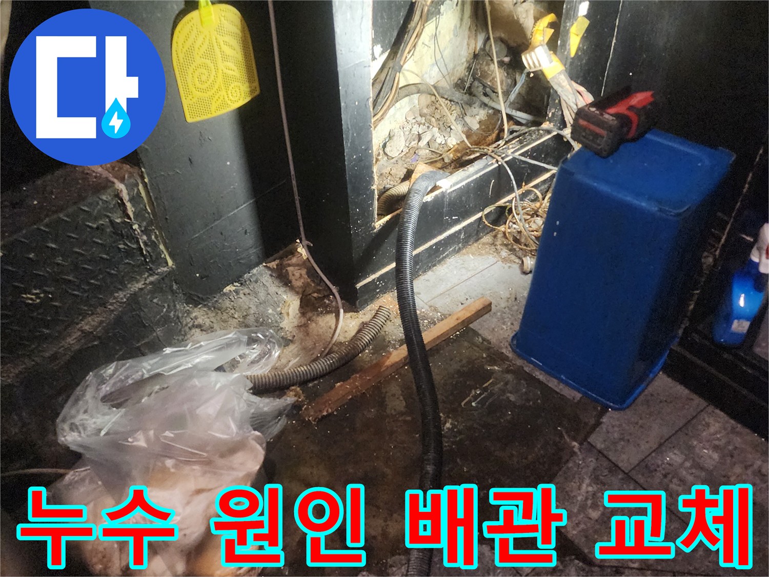 어둡고 복잡한 공간에서 누수 원인을 파악한 후 손상된 배관을 교체하기 위해 작업하는 현장-주변에는 물에 젖은 흔적과 공사 자재가 보입니다