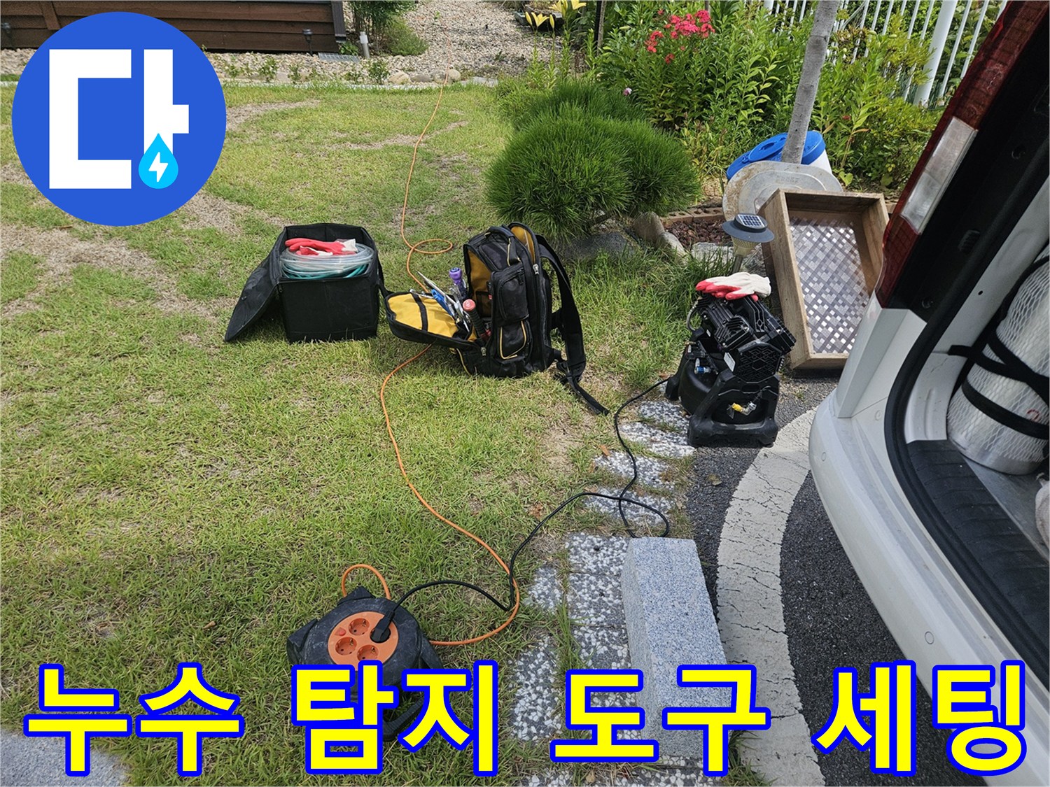검은색 배낭과 주황색 전선 릴이 놓인 작업 현장 모습