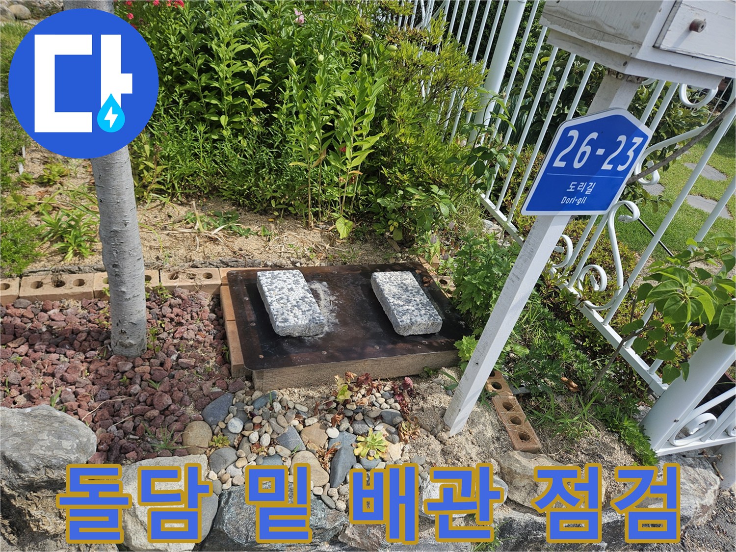 돌담-아래-자갈길-및-노출된-배관-점검-중인-사진