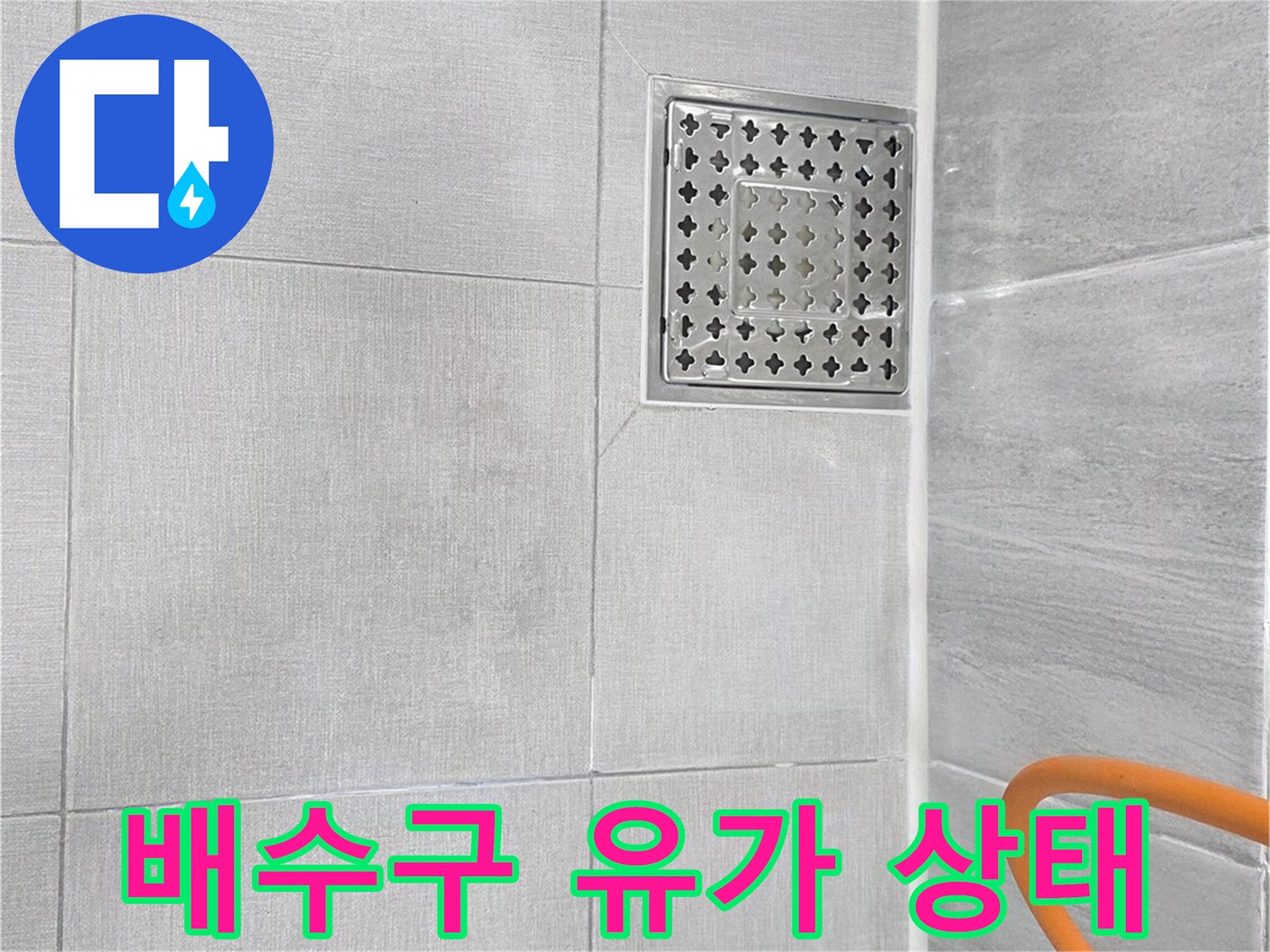 금속 재질의 배수구 덮개와 주변 타일 마감면