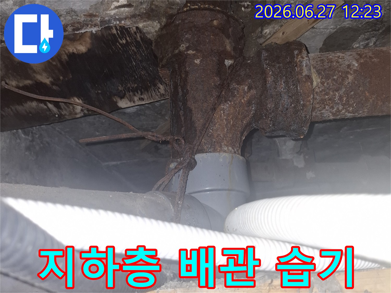 아파트 지하층의 오래된 배관에서-누수로 인해 발생한 심각한 습기 문제를-보여주는 현장 점검 사진입니다