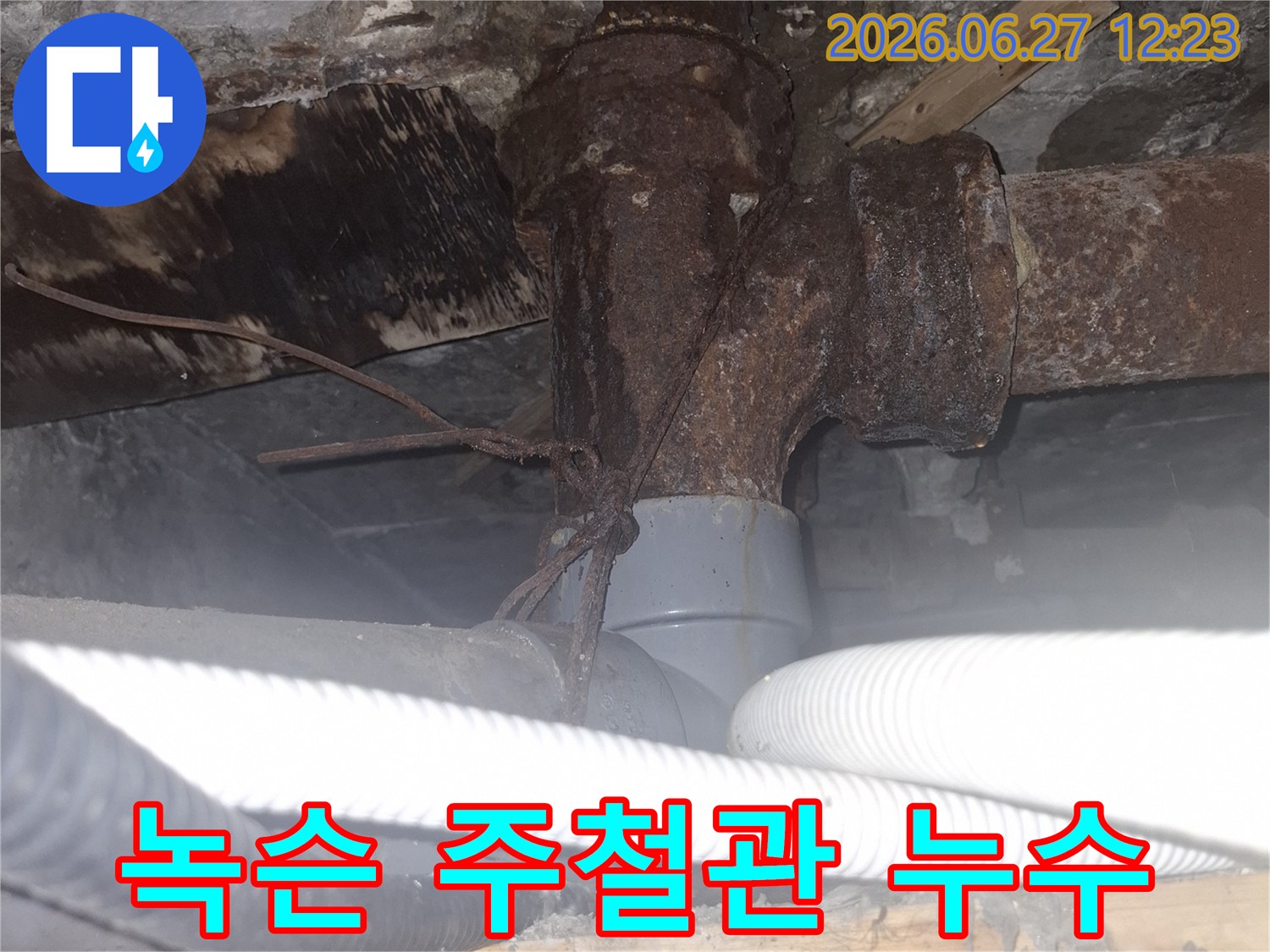 오래된 아파트의 녹슨 주철 배관에서-발견된 심각한 누수 현장을-전문가가 진단하는 모습의 사진입니다