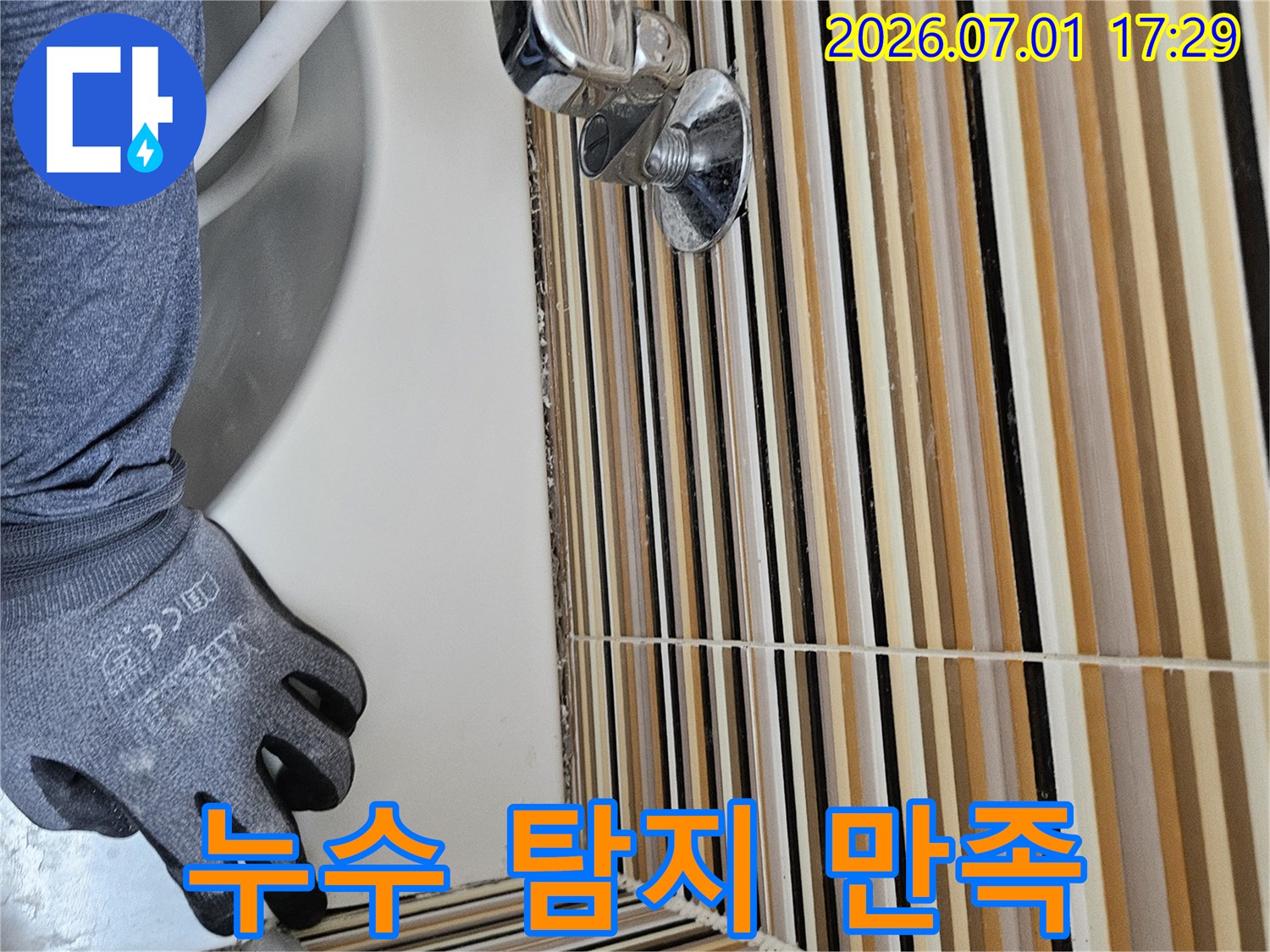 누수 전문 엔지니어가-세면대 하부 배관의-누수 지점을 정확하게 탐지하고-고객에게 만족스러운 결과를 제공하기 위해-작업하는 모습