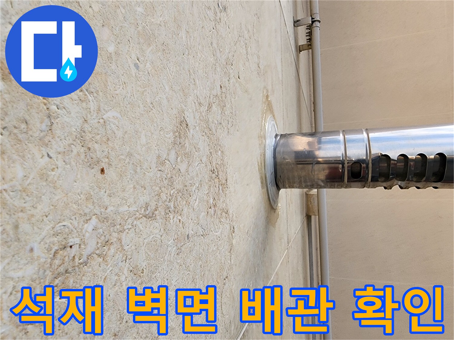 외벽 석재 마감과 스테인리스 관의 연결 지점 근접 촬영