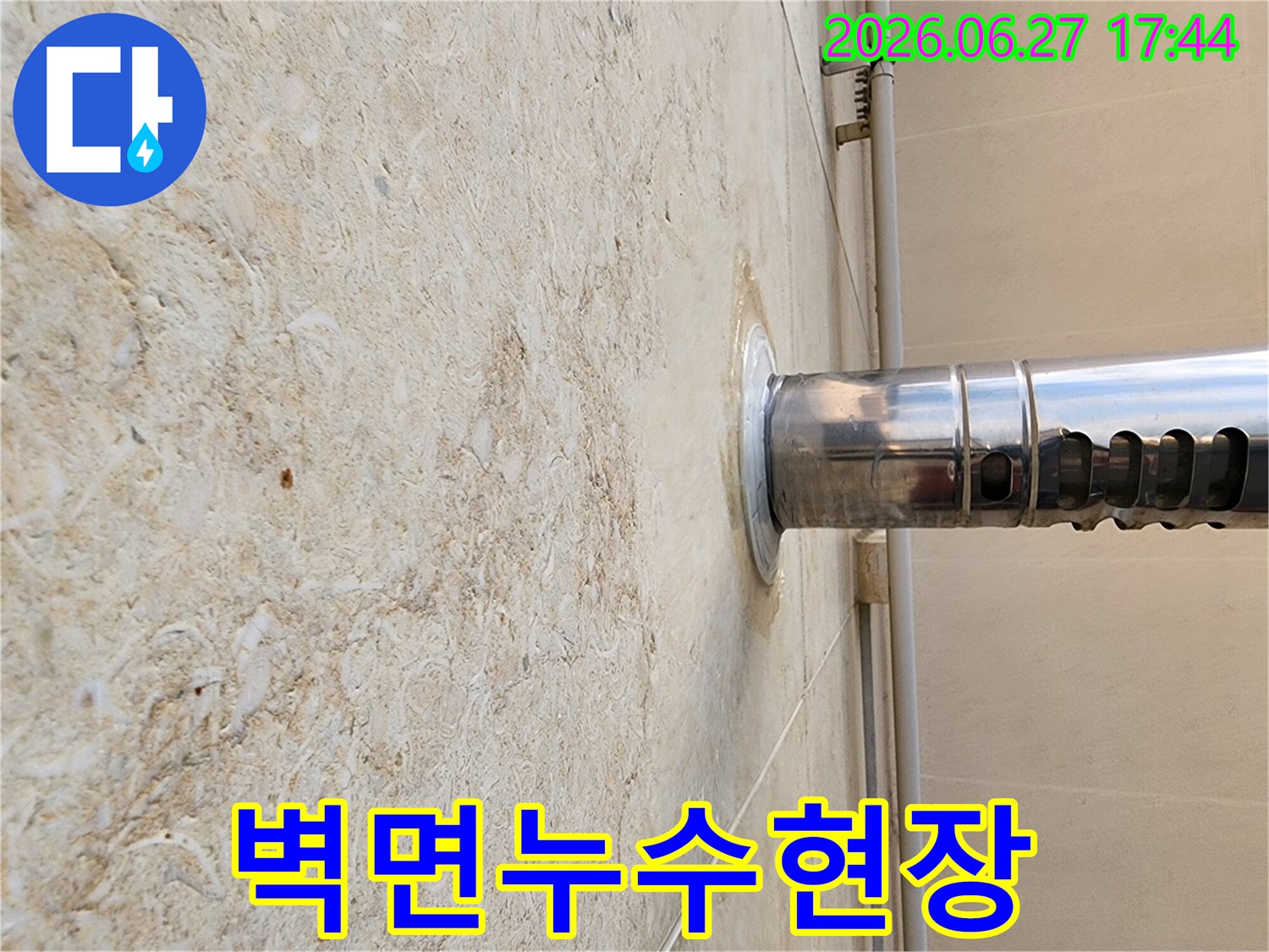 외벽에-설치된-금속-배관-연결부위에서-발생한-물-새는-현장을-촬영한-사진