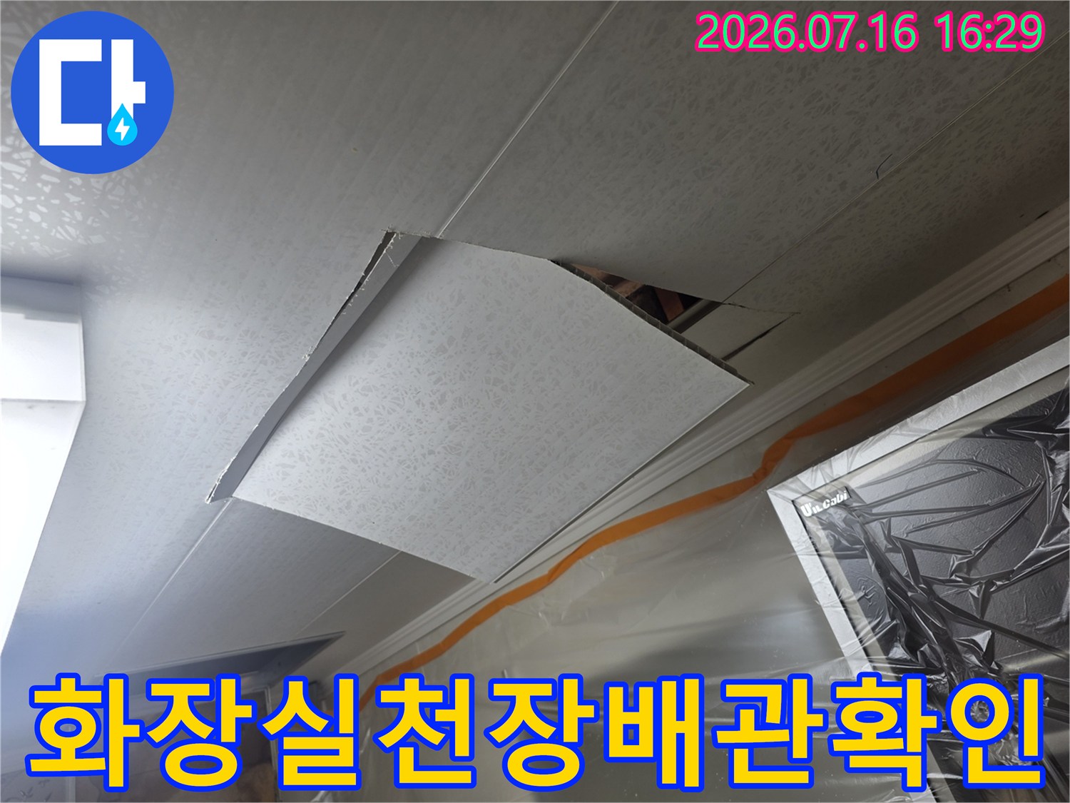 화장실 천장 마감재를 열고 내부 배관 상태를 점검하는 모습