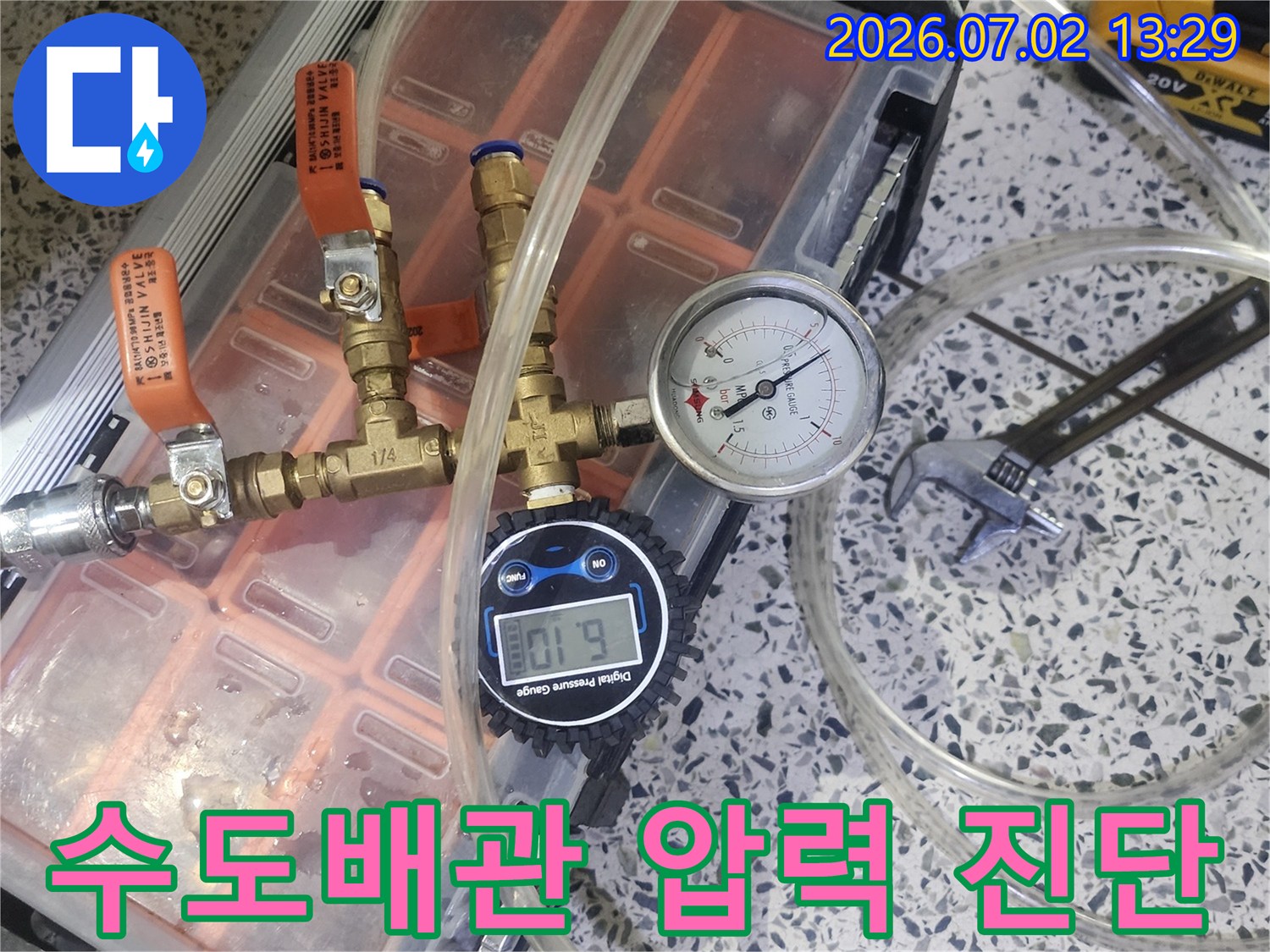 수도배관의 누수 여부를 확인하기 위해 압력 게이지가 연결된 전문 테스트 장비를 사용하고 있습니다