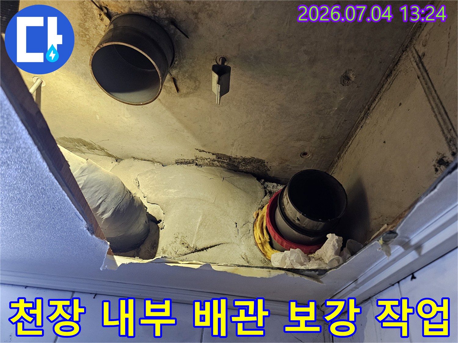 보온재에 싸인 천장 내 배관을 점검하고 수리하는 현장