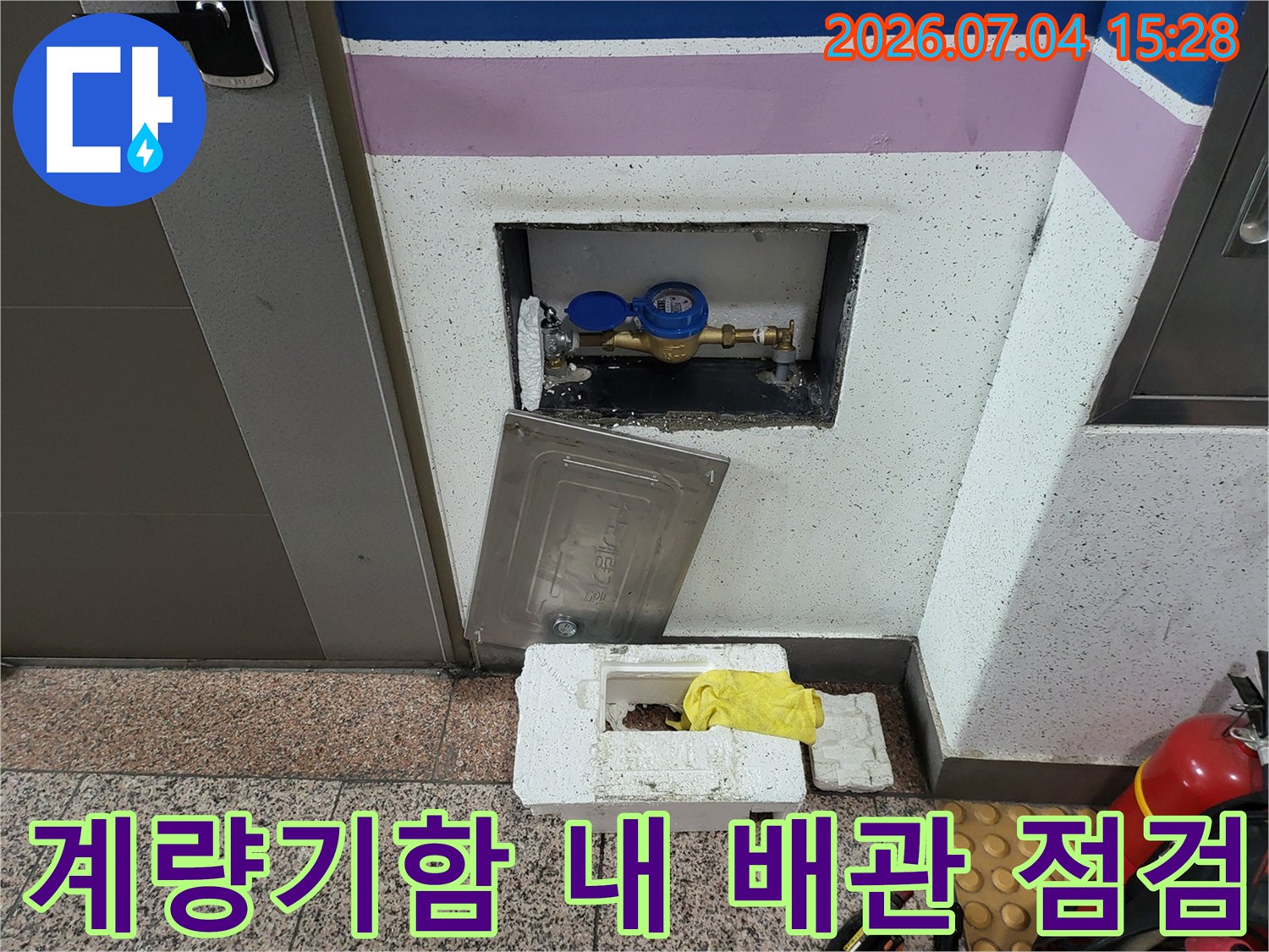 노출된 파란색 밸브와 연결 부위가 있는 계량기함 내부 구조물