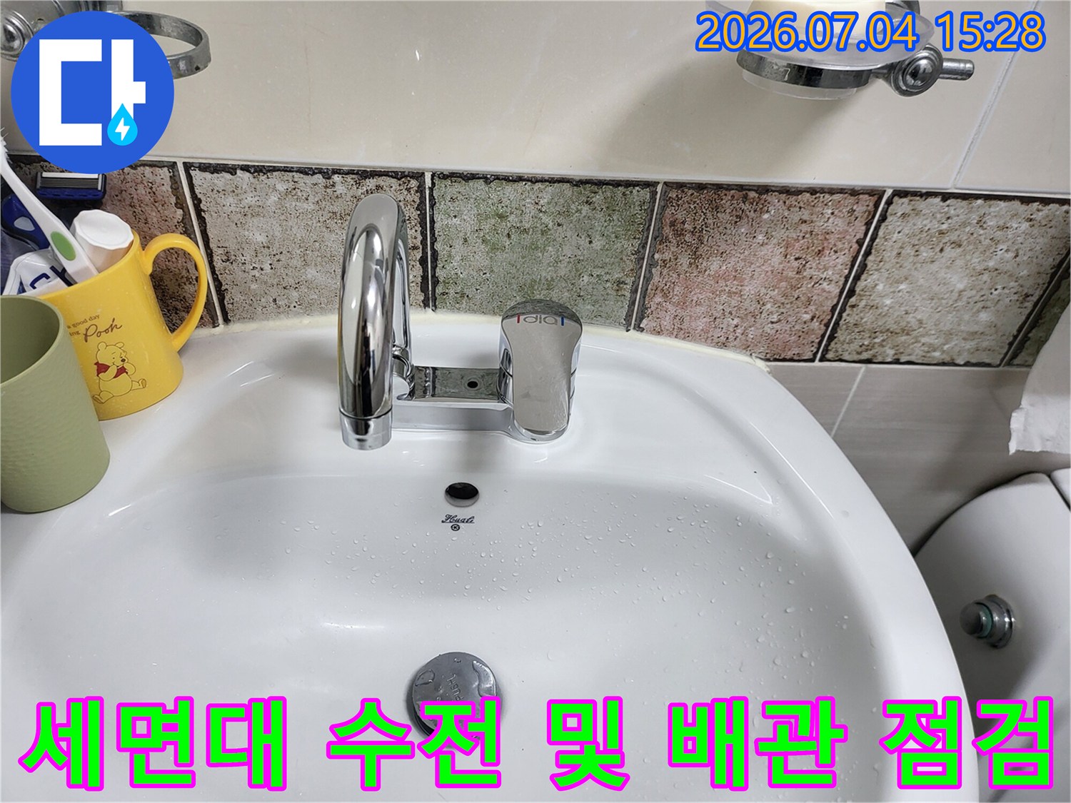 세면대 위에 설치된 수도 수전과 주변 타일 마감 상태