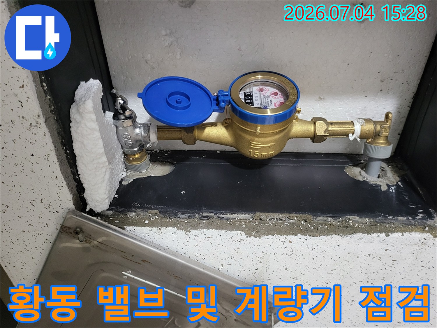 파란색 커버가 있는 수도계량기와 황동 배관의 상세 모습