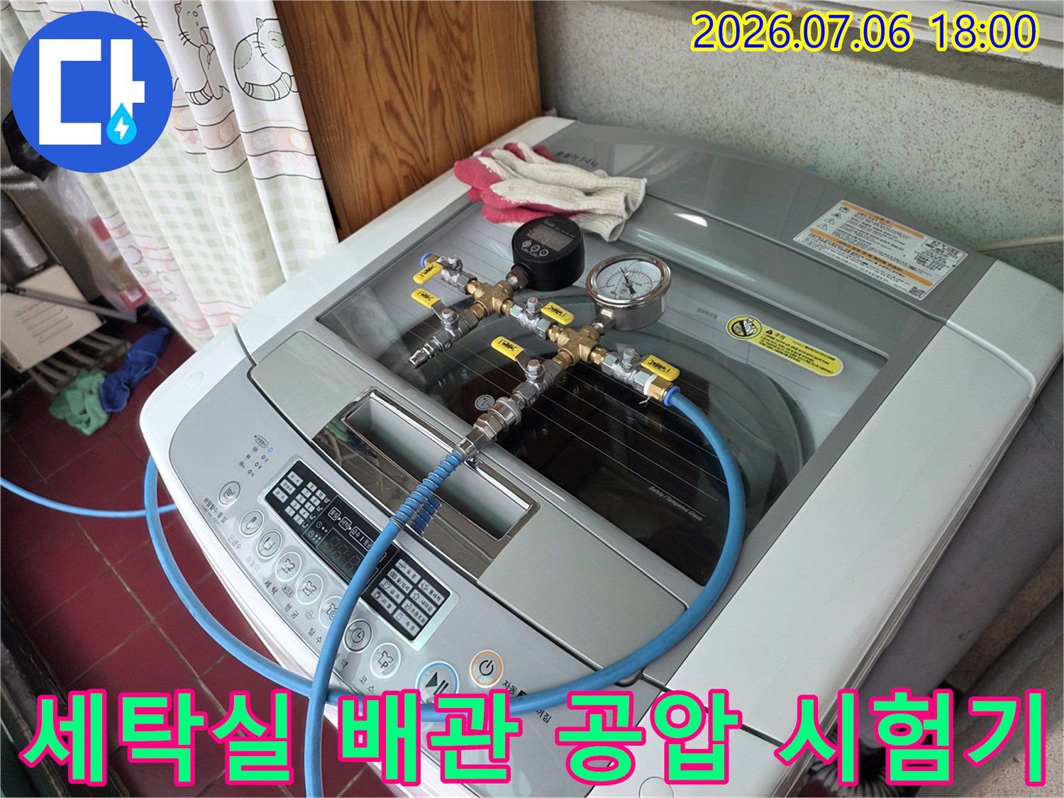 압력계와 파란색 호스가 세탁기 위쪽 배관에 연결된 모습