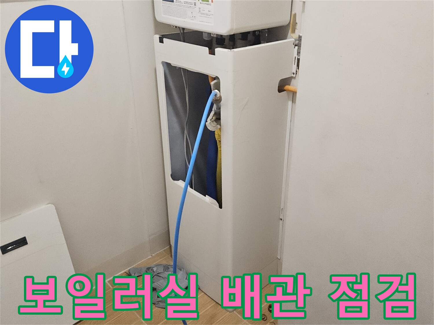 보일 быть실 내부의 파란색 호스와 배관 연결 부위 점검 중