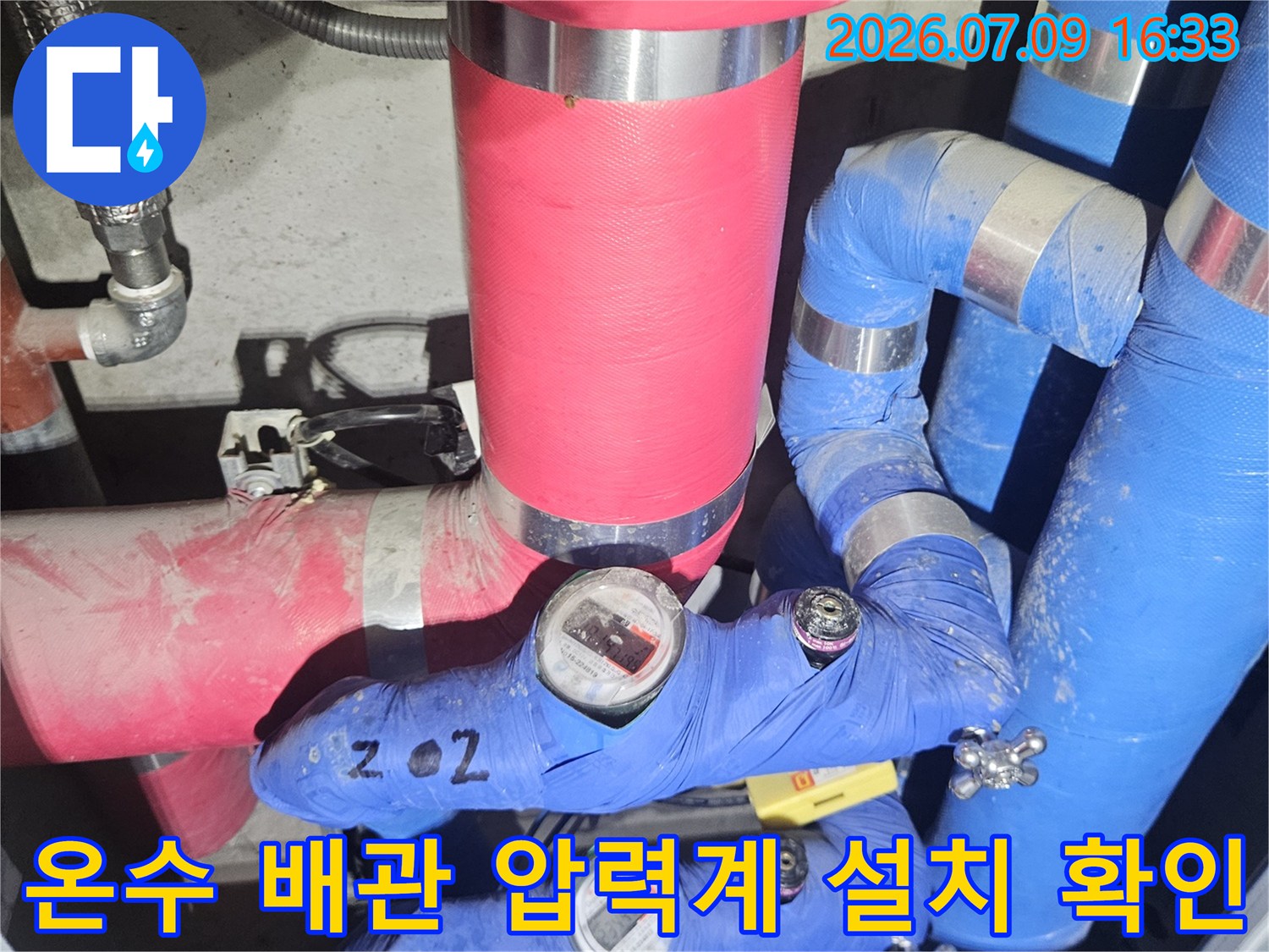 파란색 보온재와 빨간색 마감재가 섞인 보일러실 배관 시스템