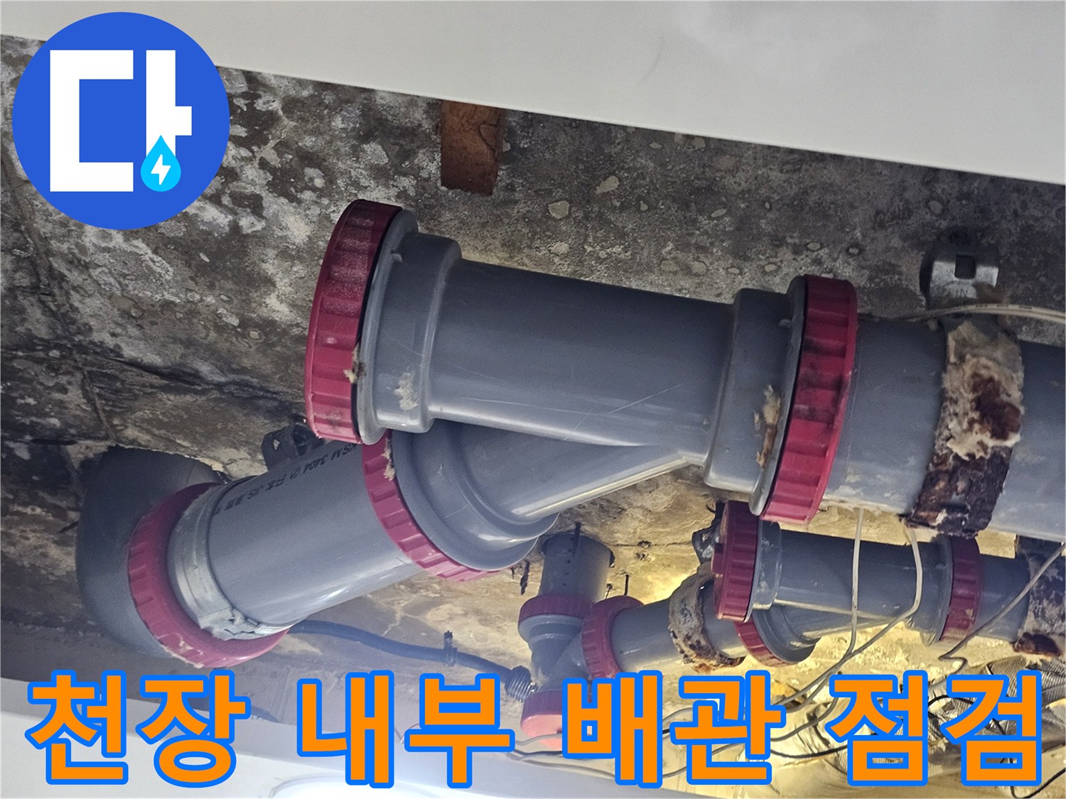습기로 인해 얼룩진 천장과 붉은색 마감재가 적용된 배관 구조