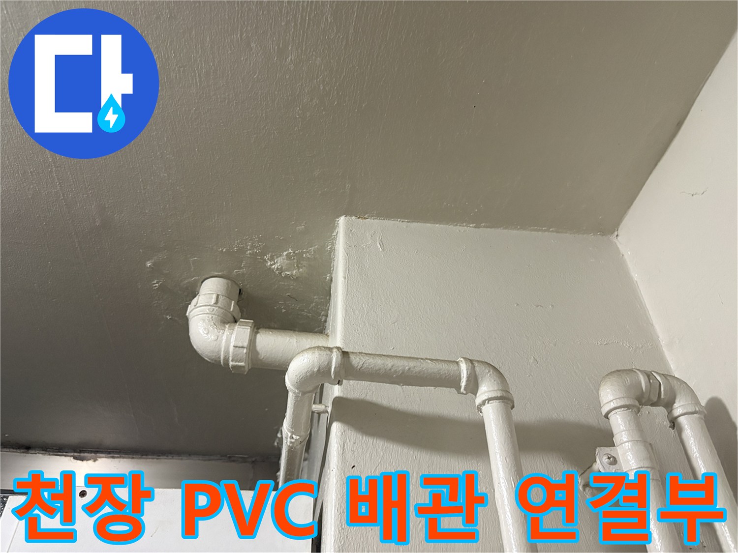 흰색으로 도장된 천장 구조물과 꺾인 형태의 배수 배관 사진입니다.
