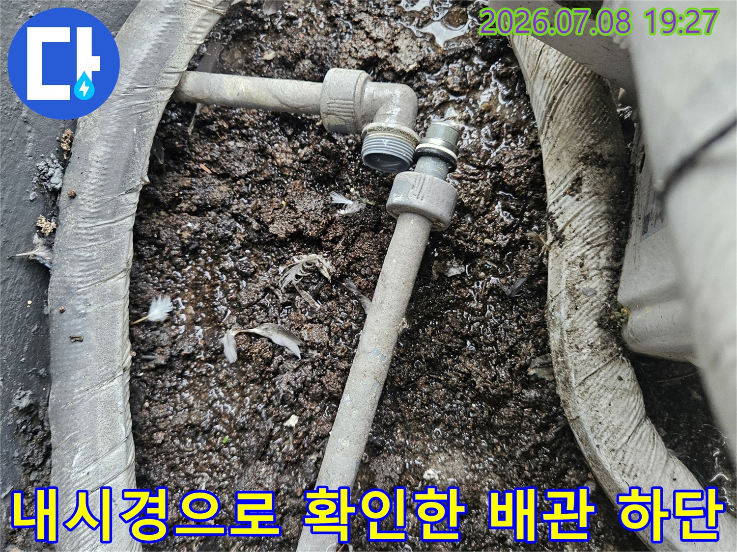 배관 주변의 젖은 토사와 연결 부위를 내시경으로 세밀하게 관찰하는 모습