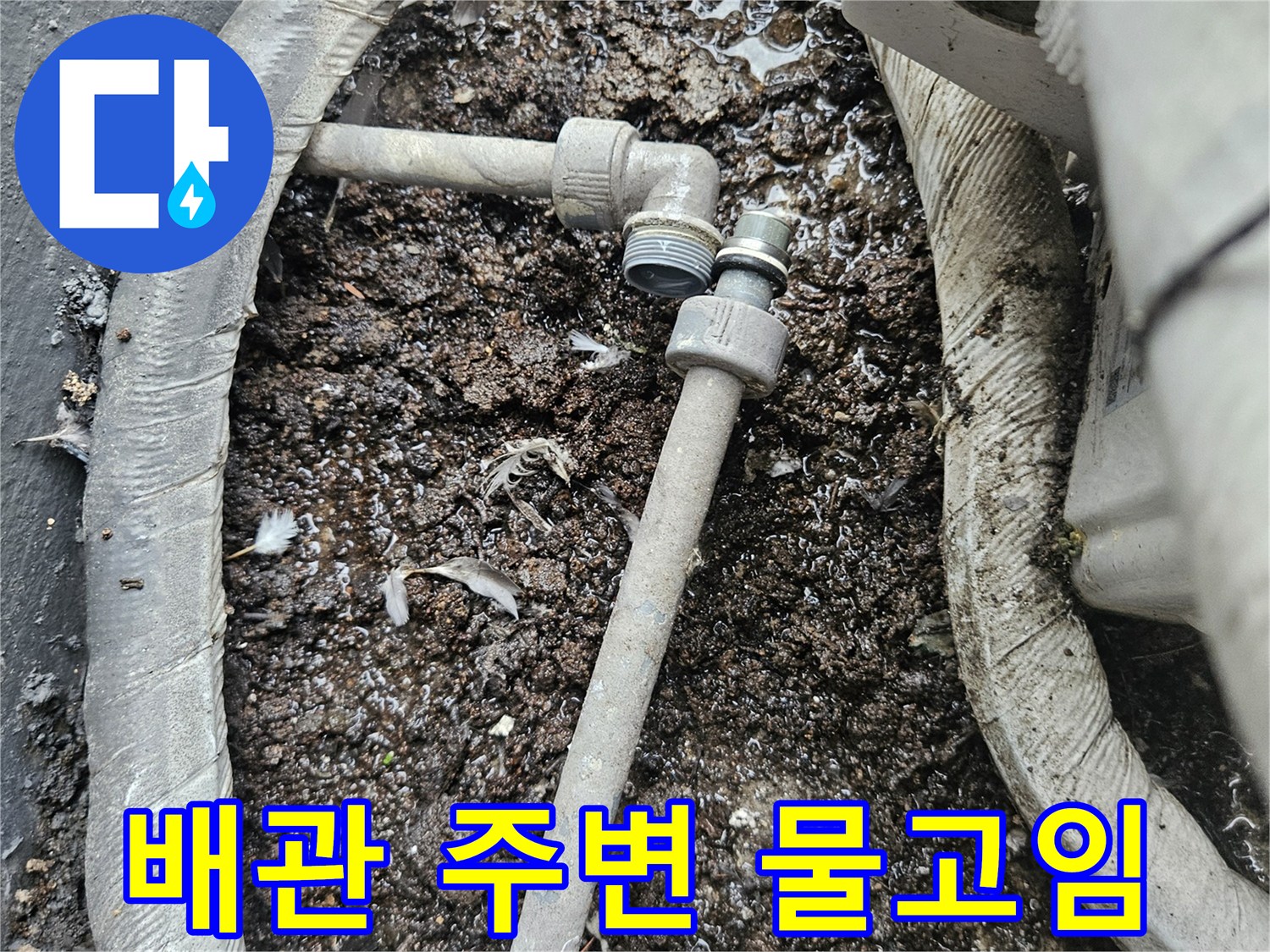 에어컨 배관 하부-습기로 젖은 흙과 이물질이 쌓인 모습