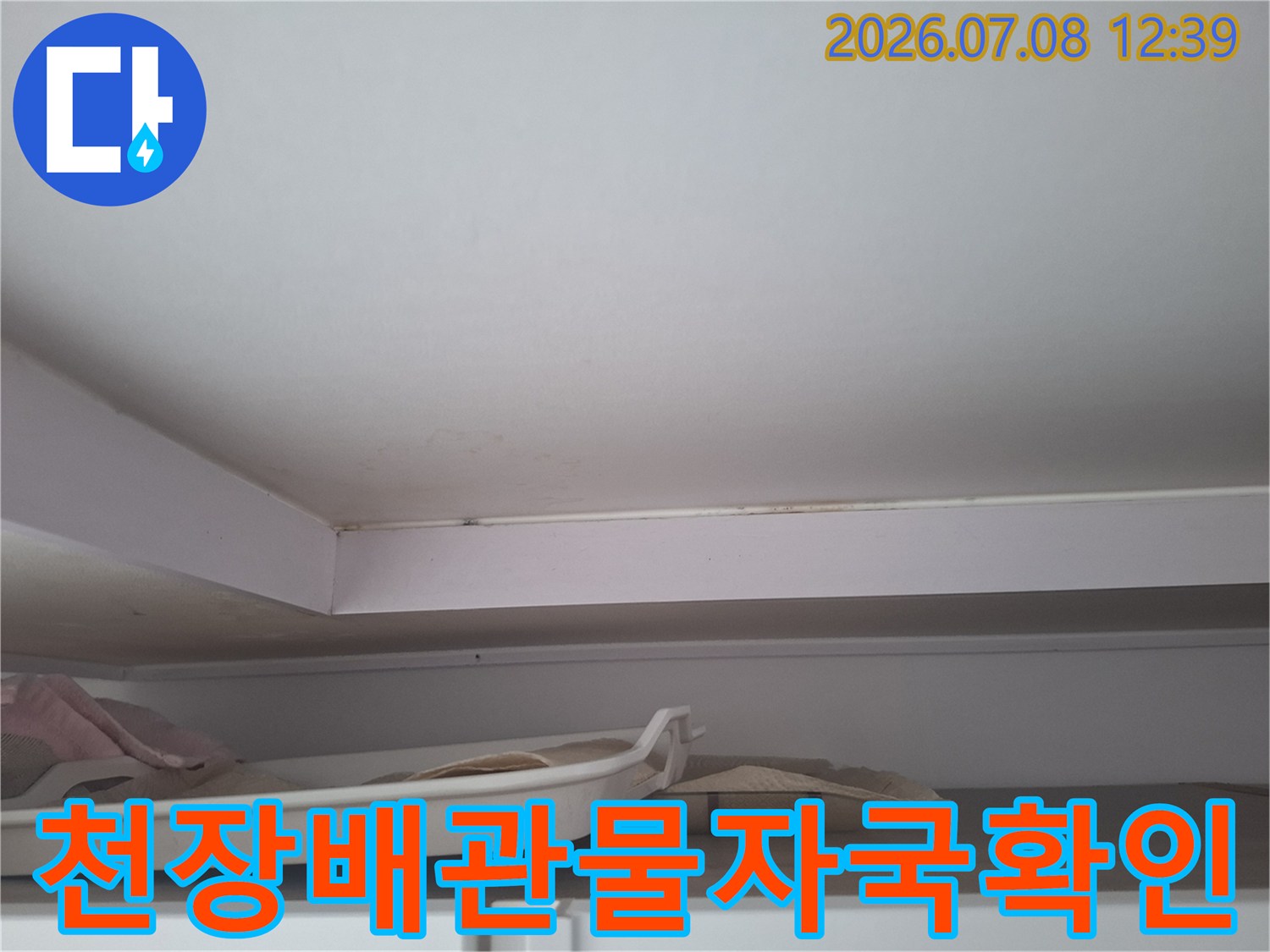 천장 구조물에 발생한 갈색 누수 흔적과 배관 부위 점검