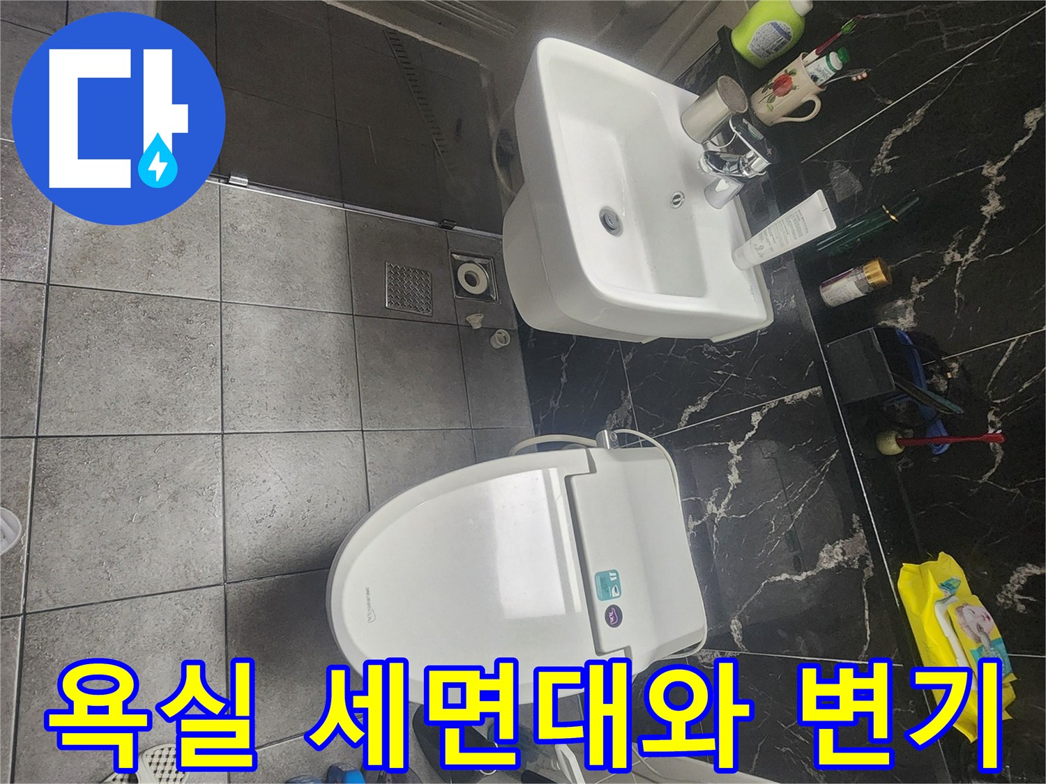 화장실 내부에 설치된 세면대와 양변기의 전체적인 배치 상태를 보여줍니다.