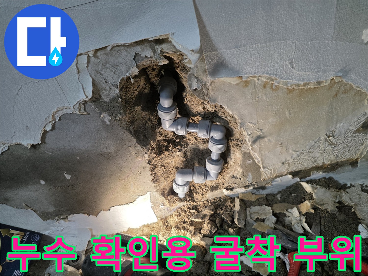 배관 노출 현장-파손된 부위의 회색 배관과 젖은 토사