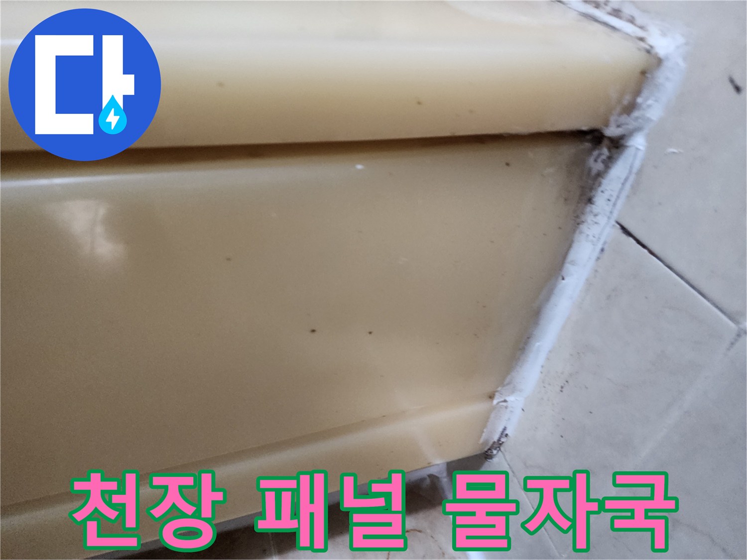 화장실 천장재 사이로 스며든 누수 흔적과 타일 경계 부위