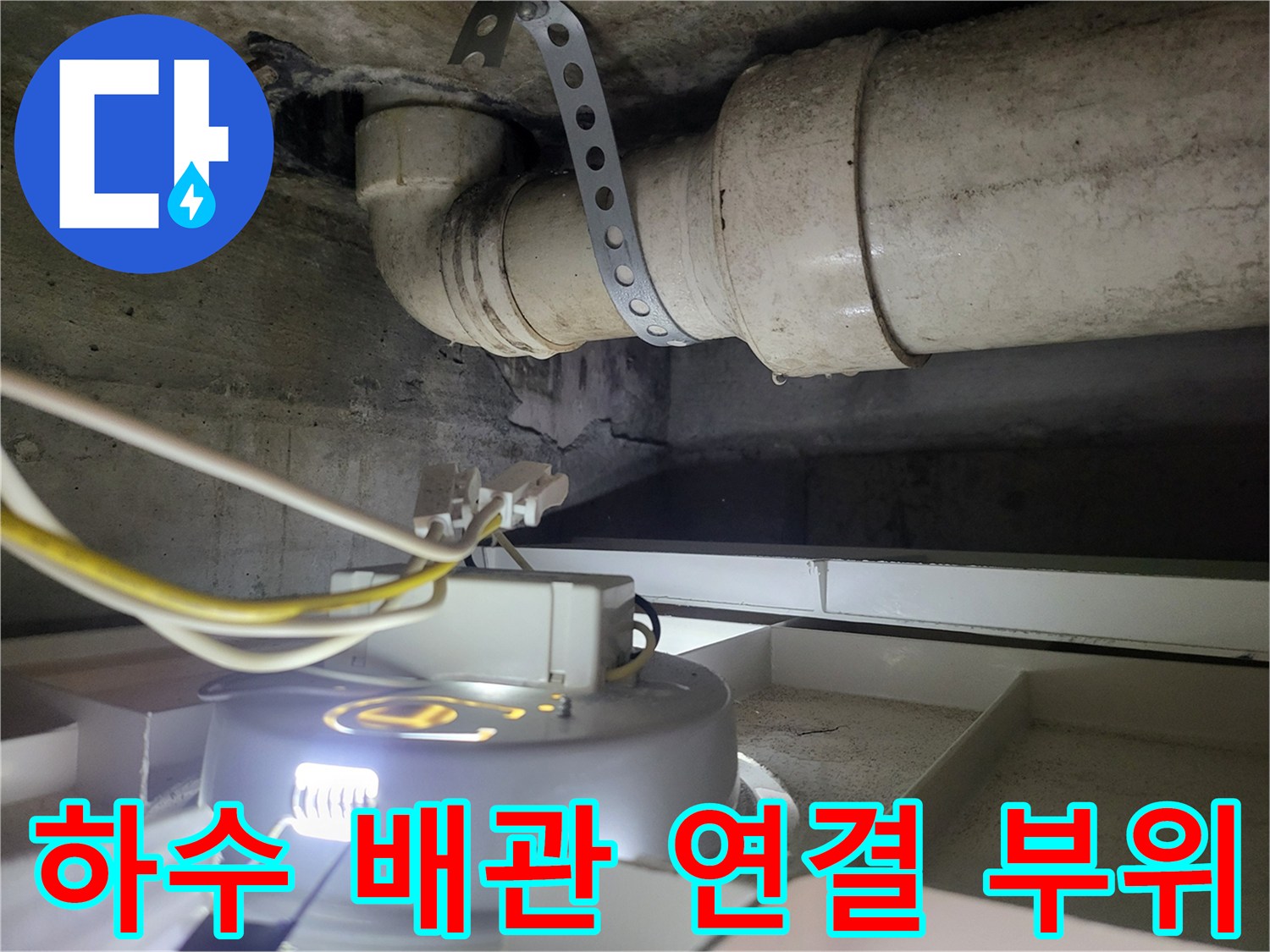 천장에 설치된 굵은 하수관과 금속 고정 장치 상세 사진