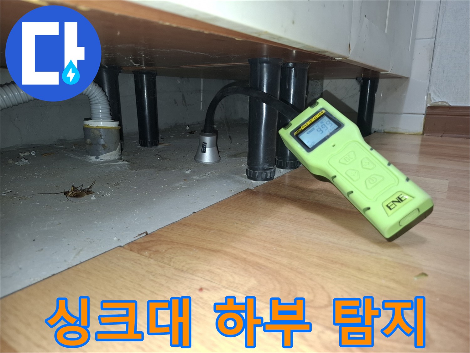 싱크대 아래 배관 주변에서 가스 탐지기로 누수를 측정하는 장면