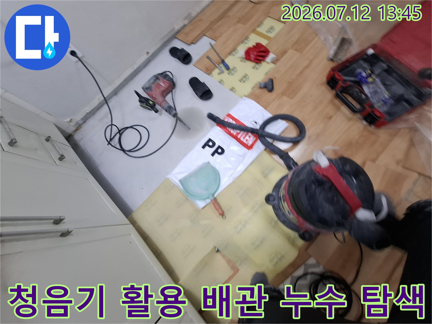 작업자가 청음기로 노란색 배관의 누수 지점을 확인하고 있는 현장 사진입니다.