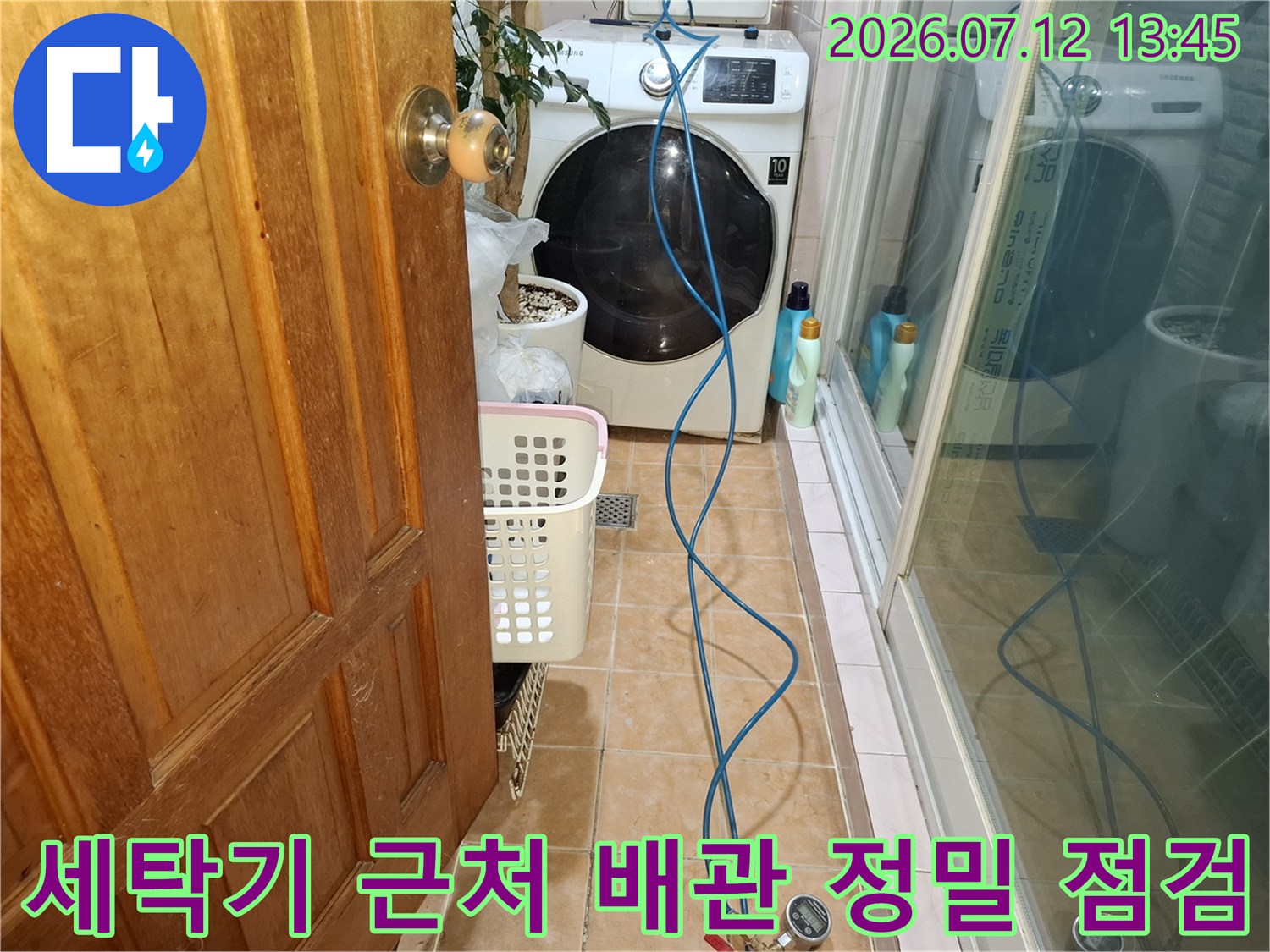 장비를 연동하여 세탁기 옆 파란색 배관을 점검하는 모습
