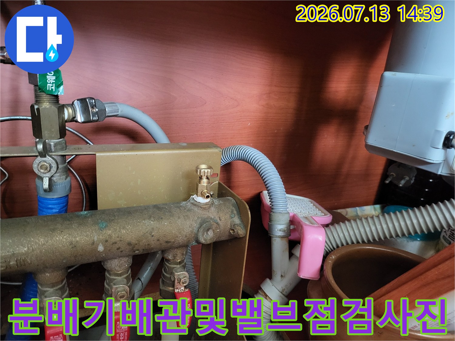 금속제-보일러-분배기와-빨간색-밸브-그리고-회색-주름관이-연결된-모습