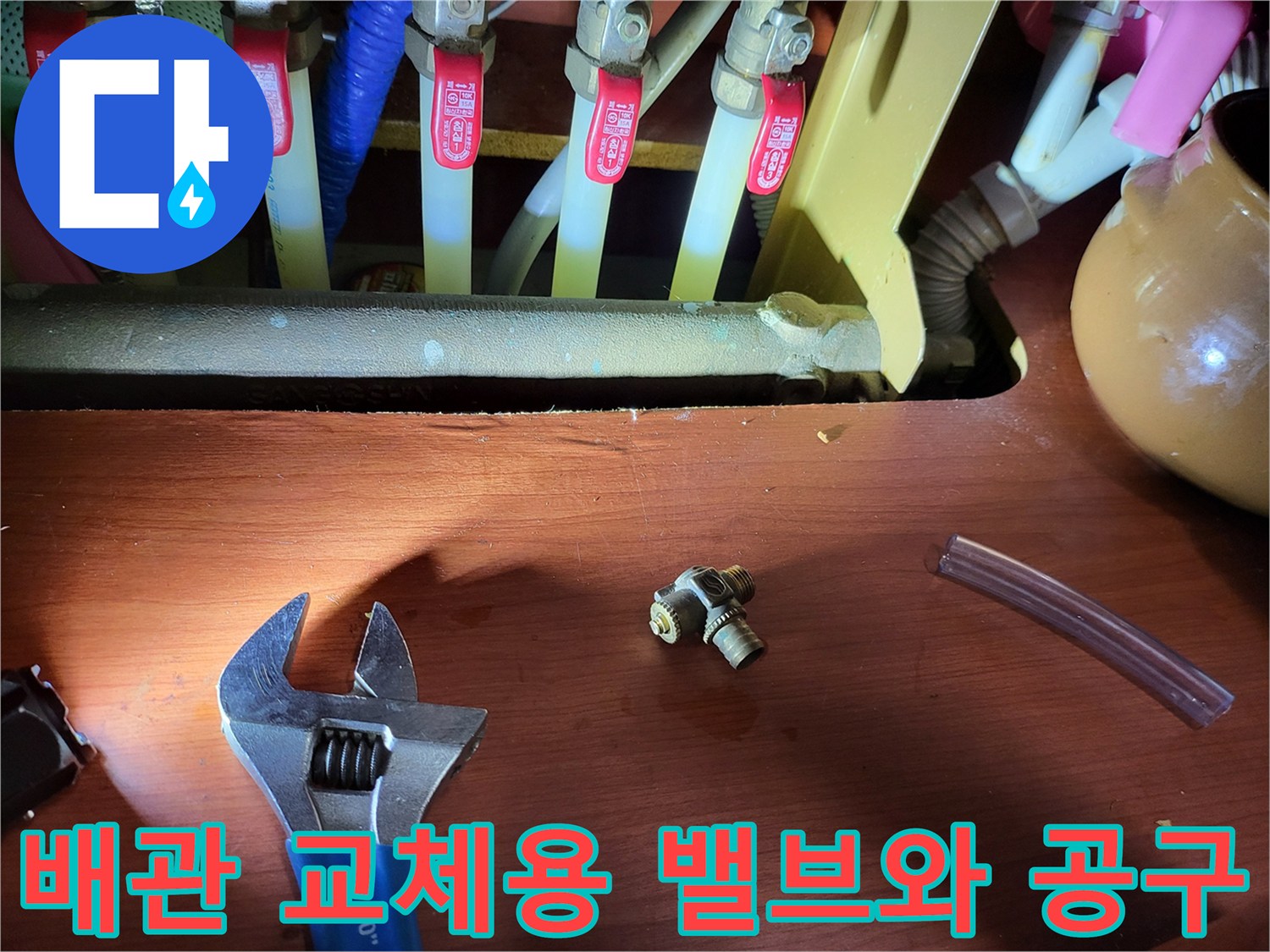 작업 현장에 놓인 새 퇴수밸브와 몽키스패너 사진