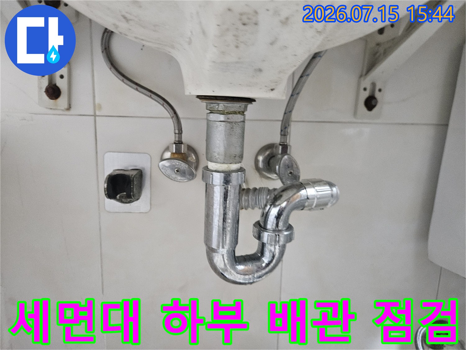 세면대 아래쪽 노출된 금속제 하수 배관과 트랩 구조물